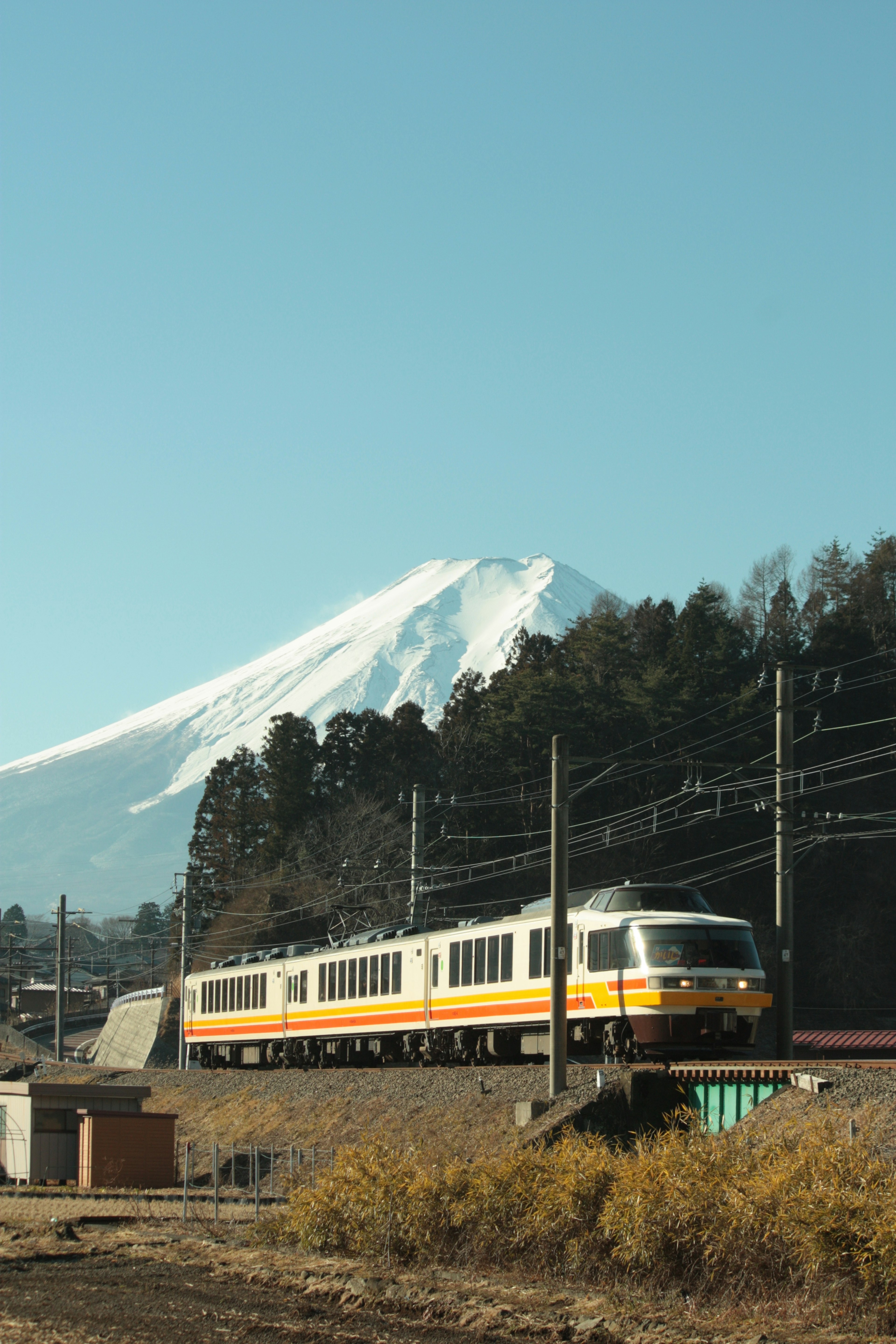 Pemandangan kereta kuning dengan Gunung Fuji di latar belakang