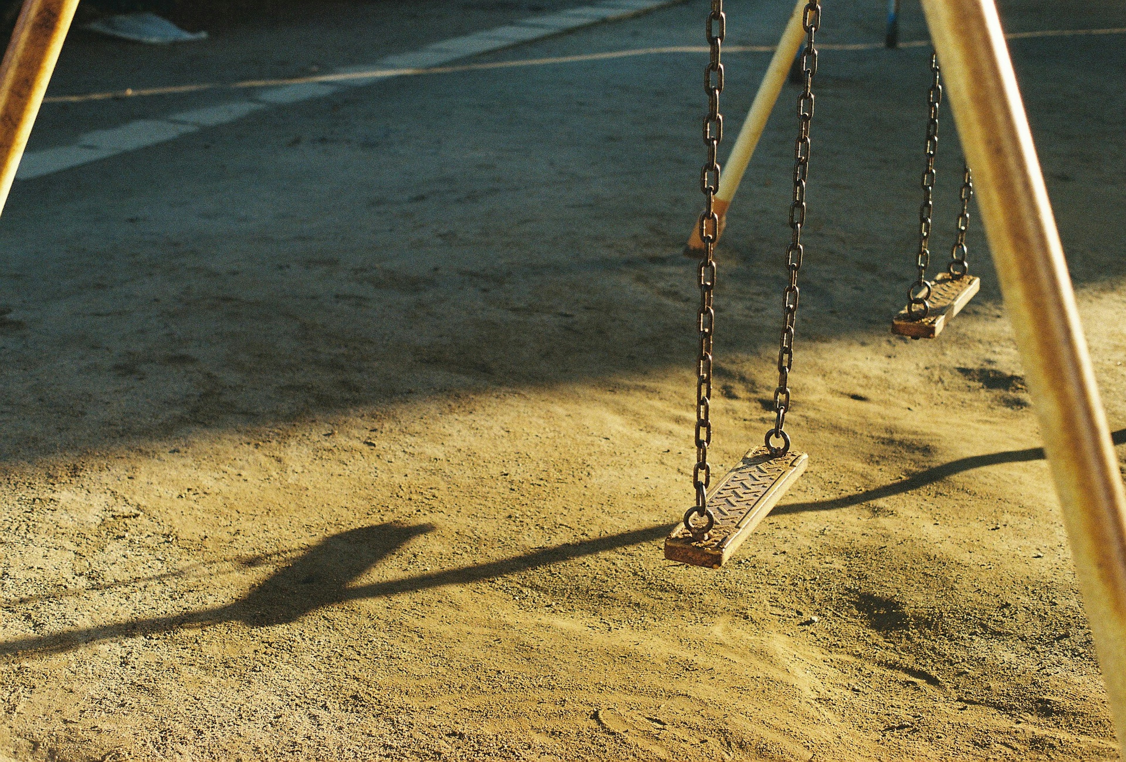 Abendliche Szene mit dem Schatten einer Schaukel im Spielplatz