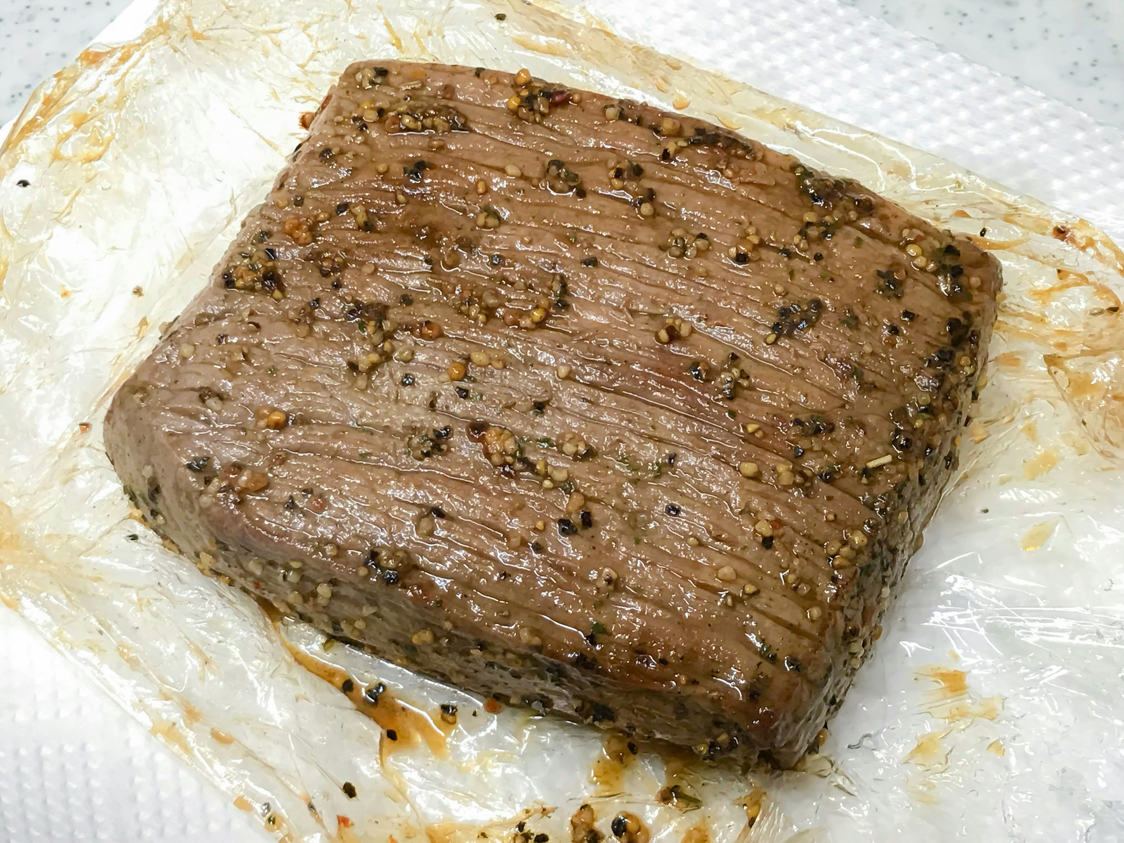 A seasoned block of meat resting on a paper towel