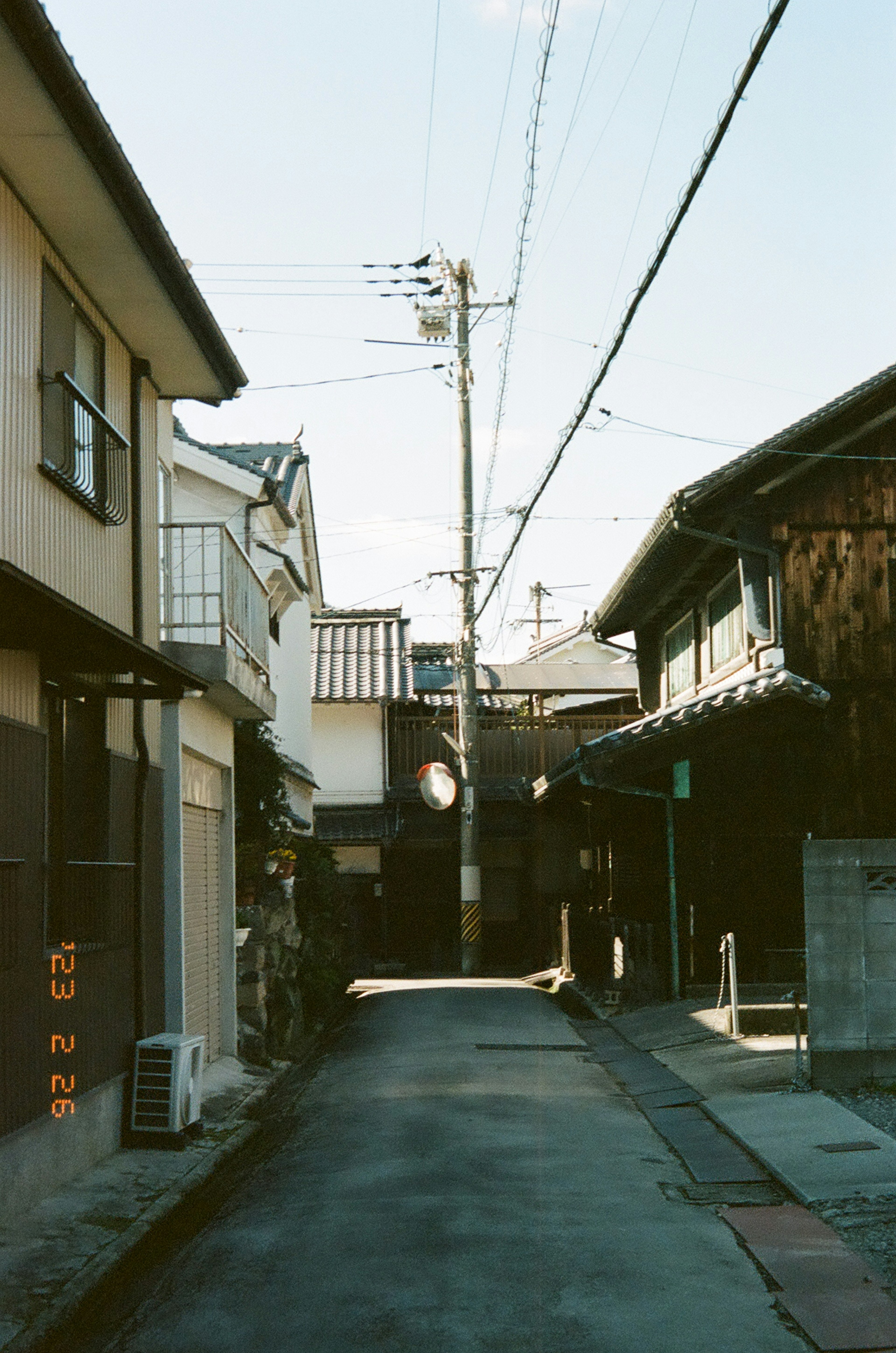 狭い路地に沿った古い建物と電柱の風景