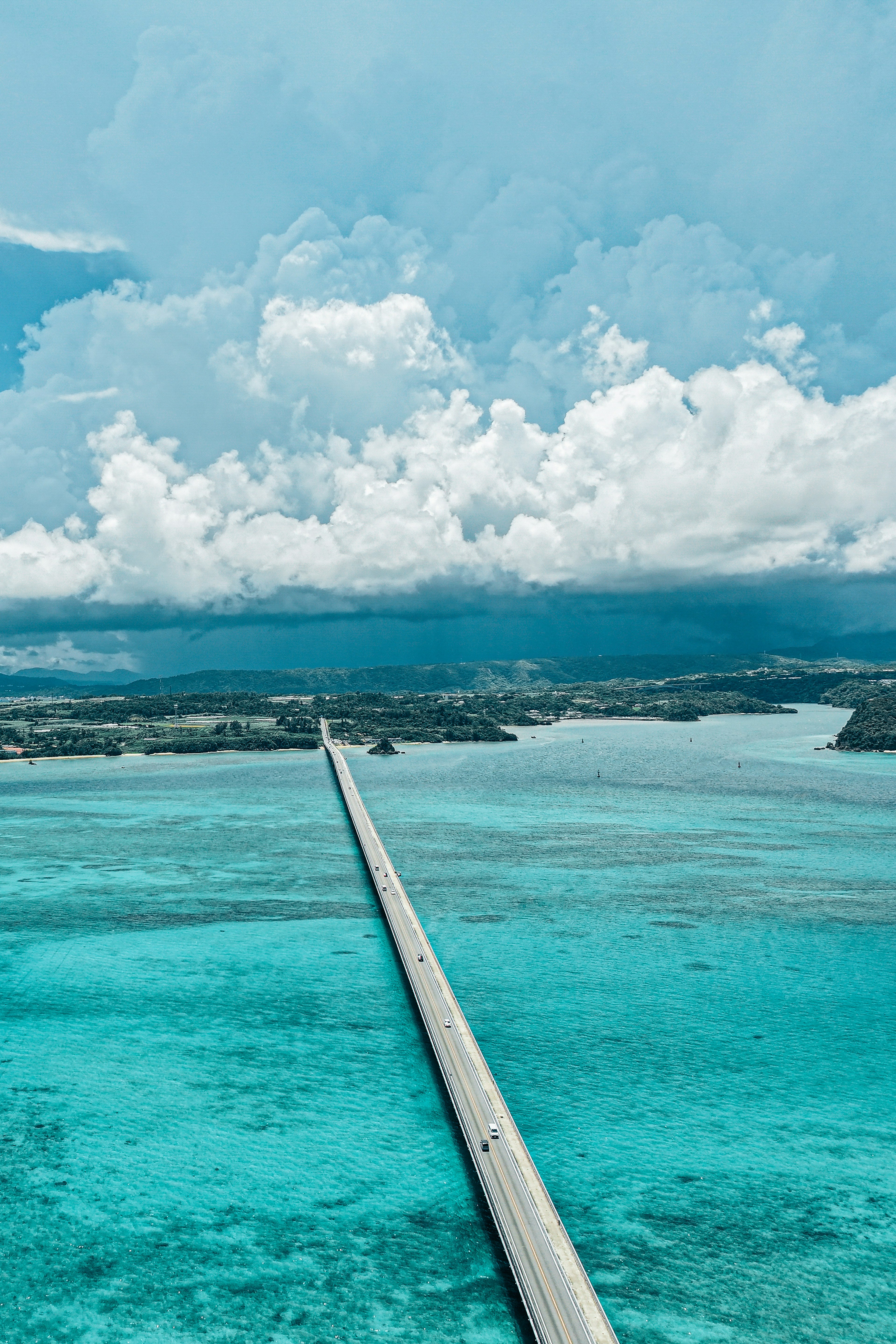 Eine lange Brücke, die sich über türkisfarbenes Wasser unter einem blauen Himmel erstreckt