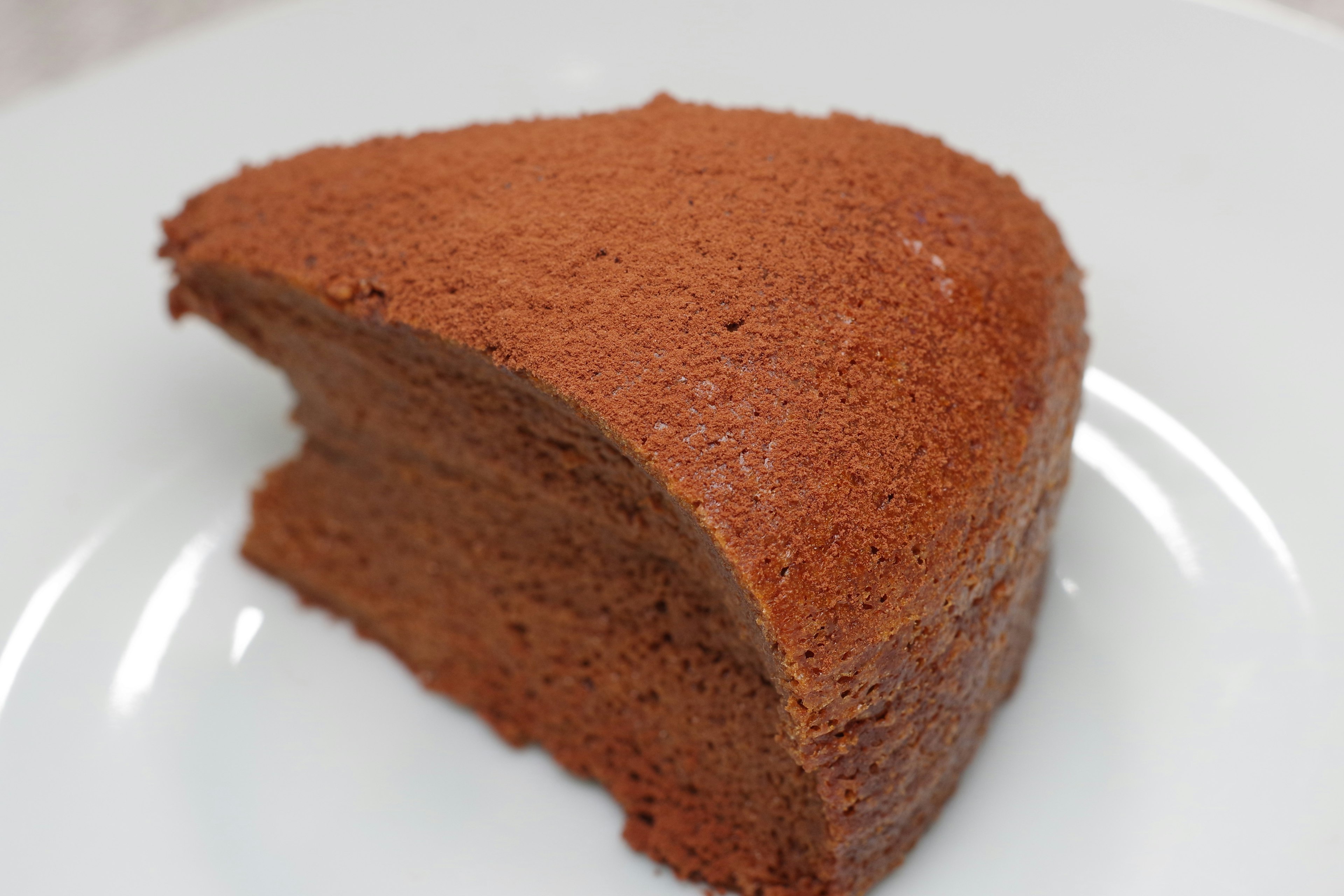 A slice of chocolate cake on a white plate