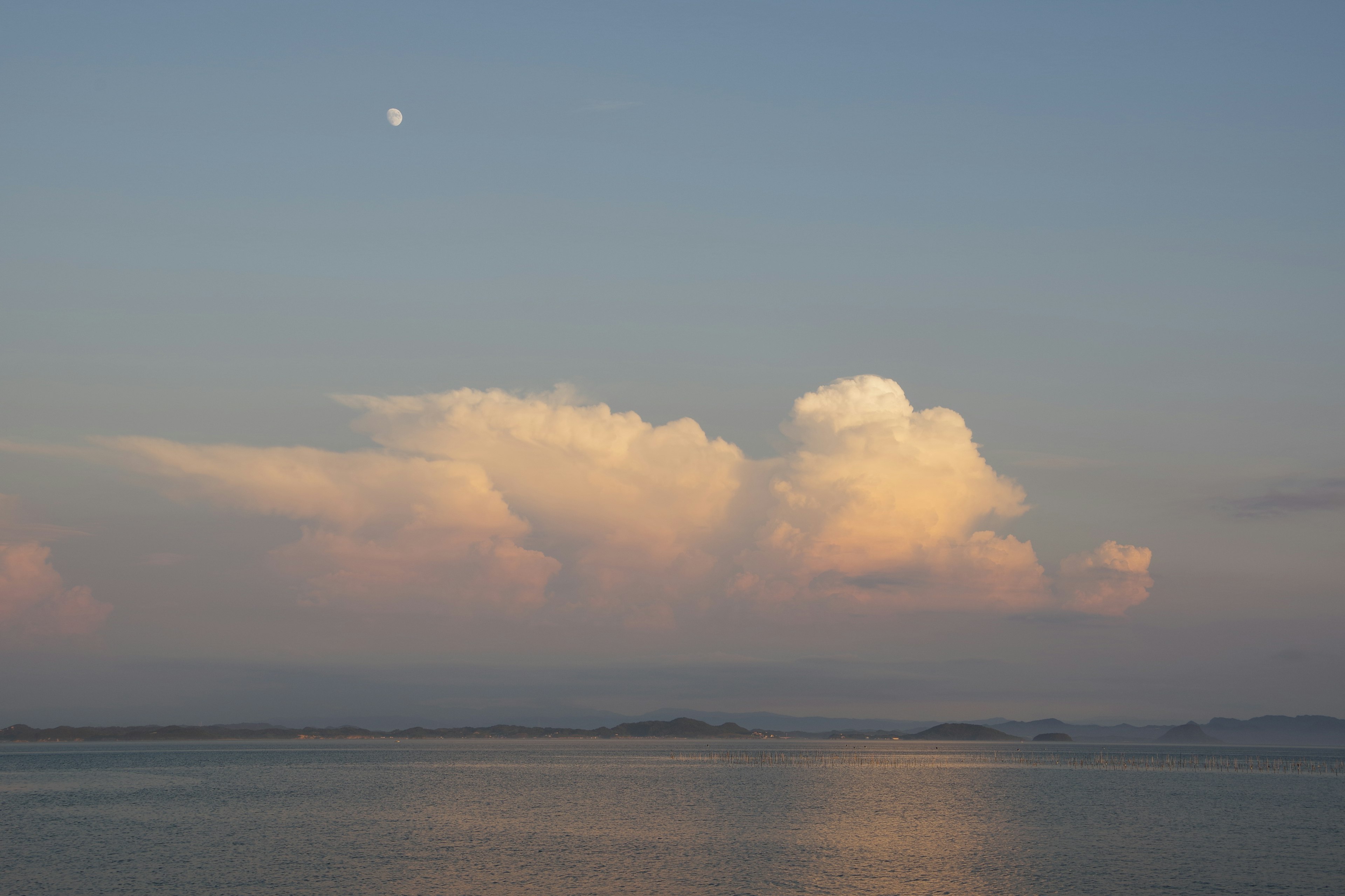 Ruhiger See mit sanften Wolken beim Sonnenuntergang