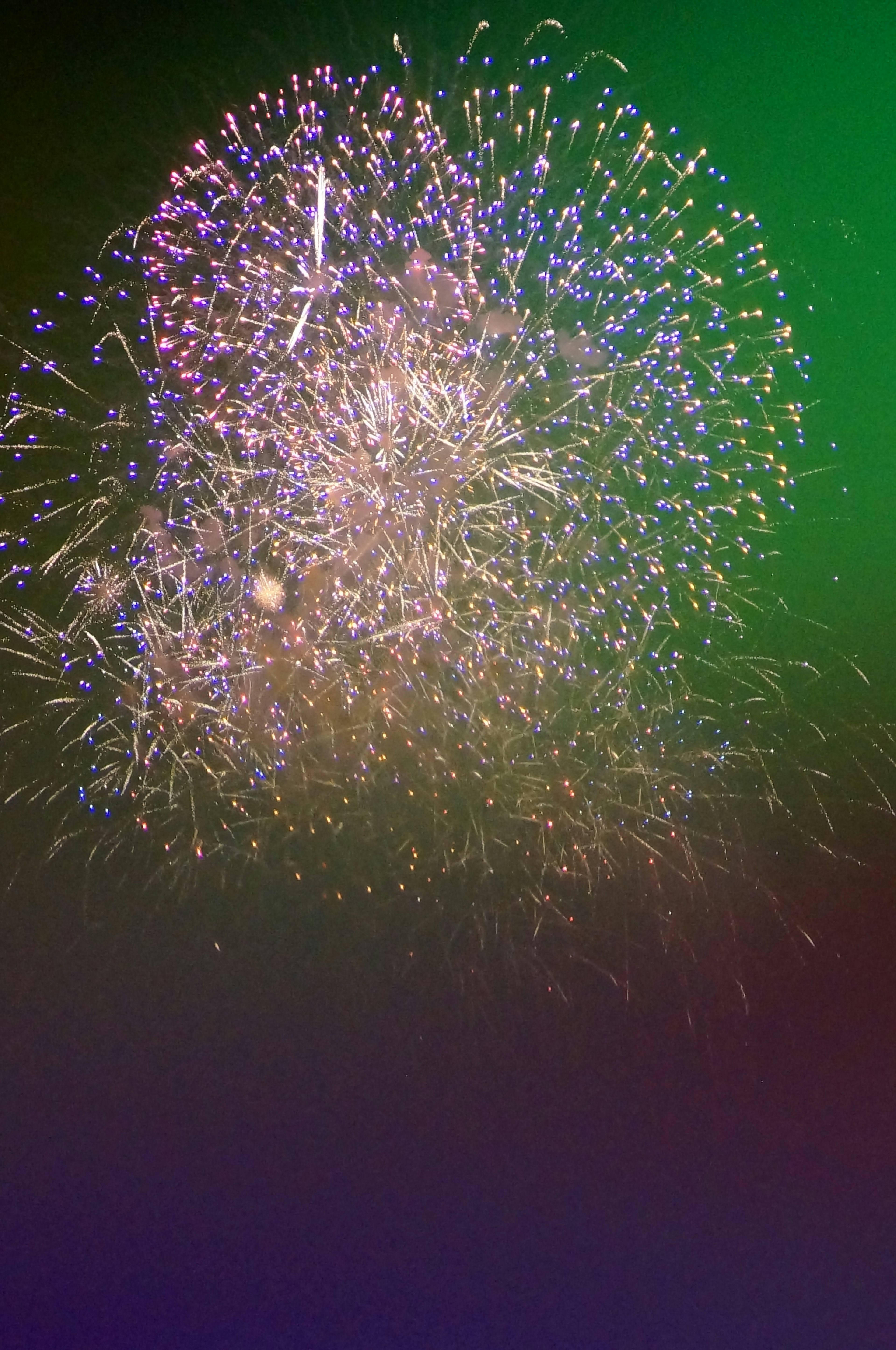 Des feux d'artifice colorés explosant sur un fond vert