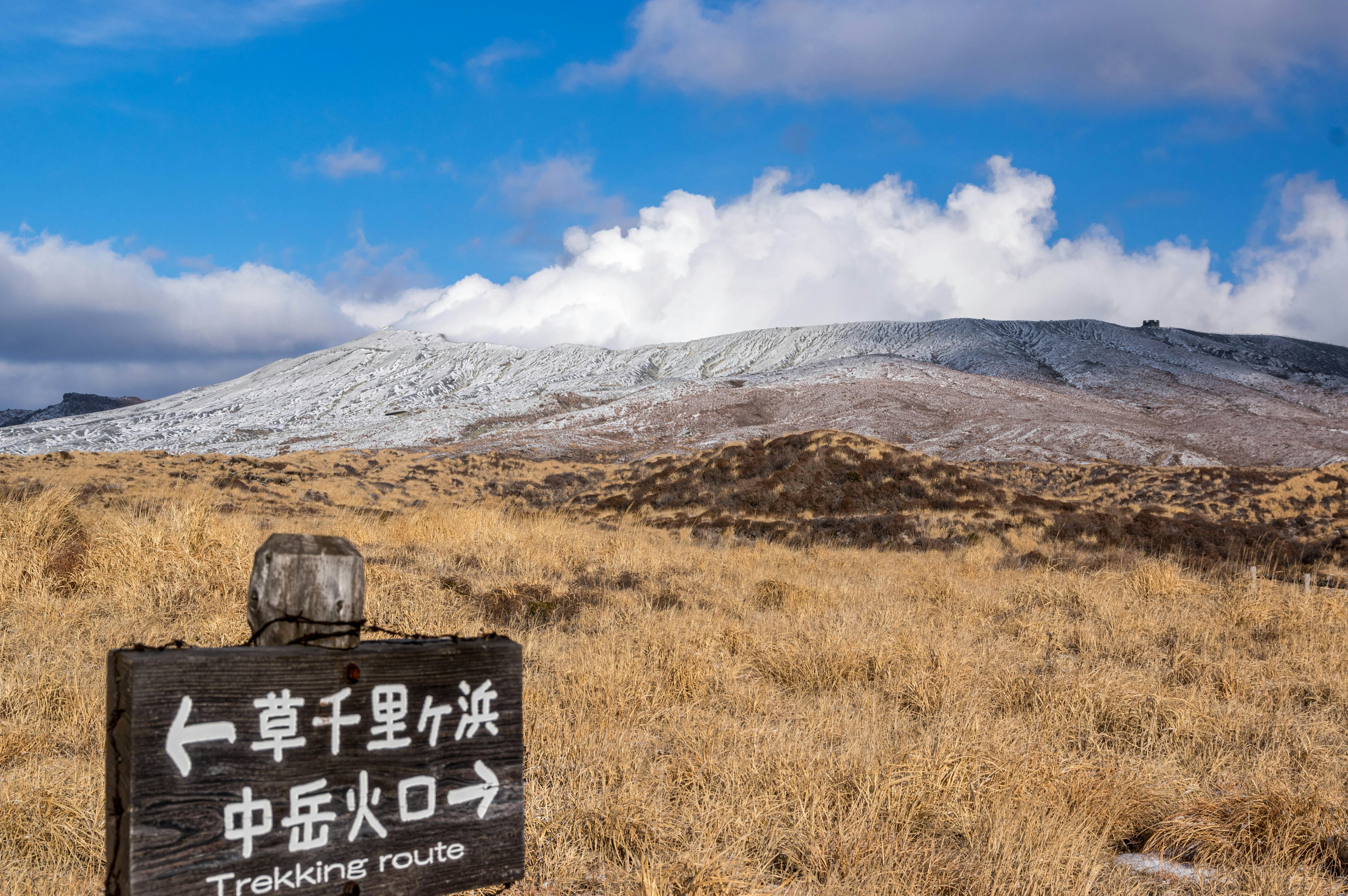 Cartel indicador para Kusasenrigahama con paisaje montañoso