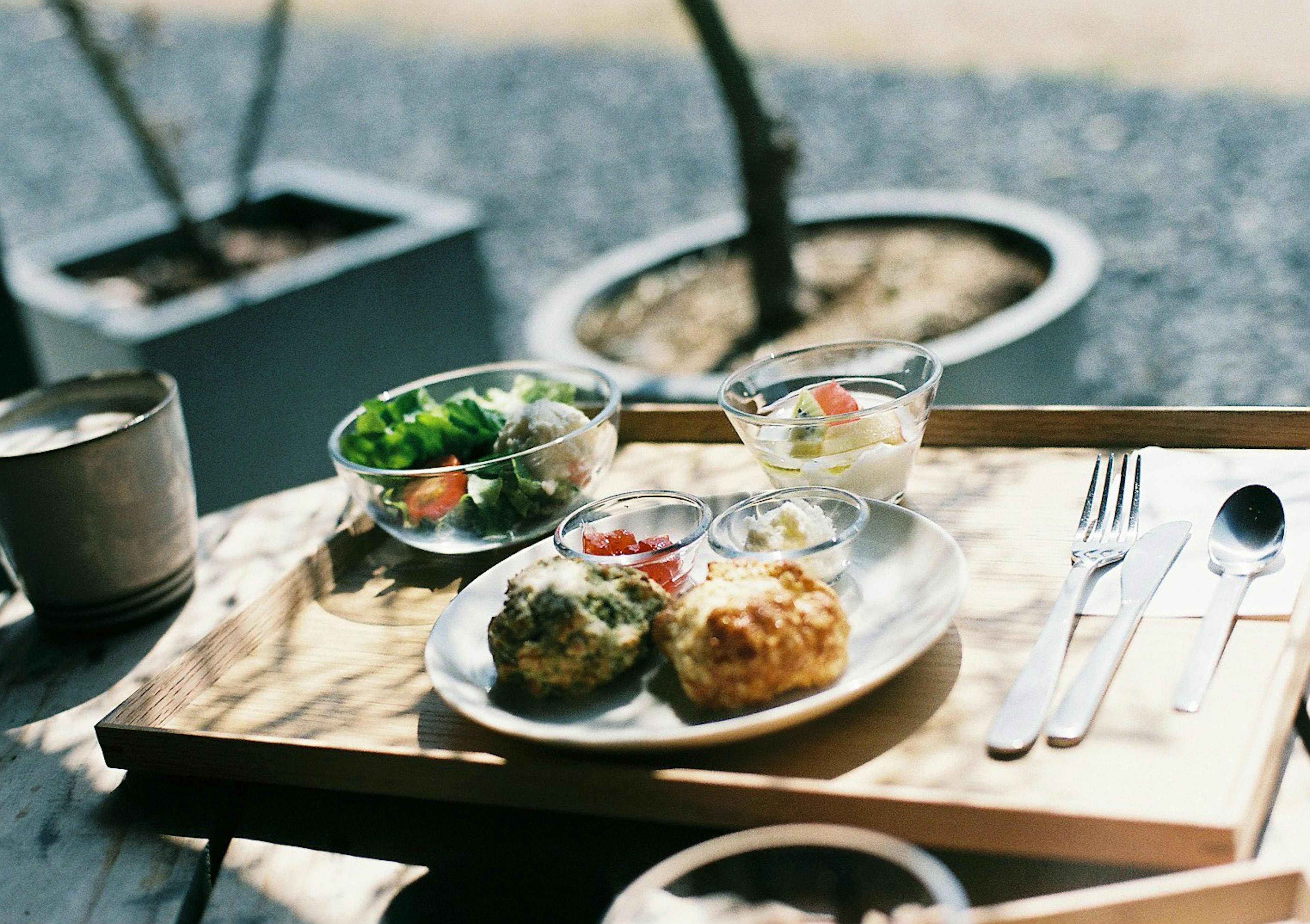 Plat présenté sur un plateau en bois avec salade et dessert