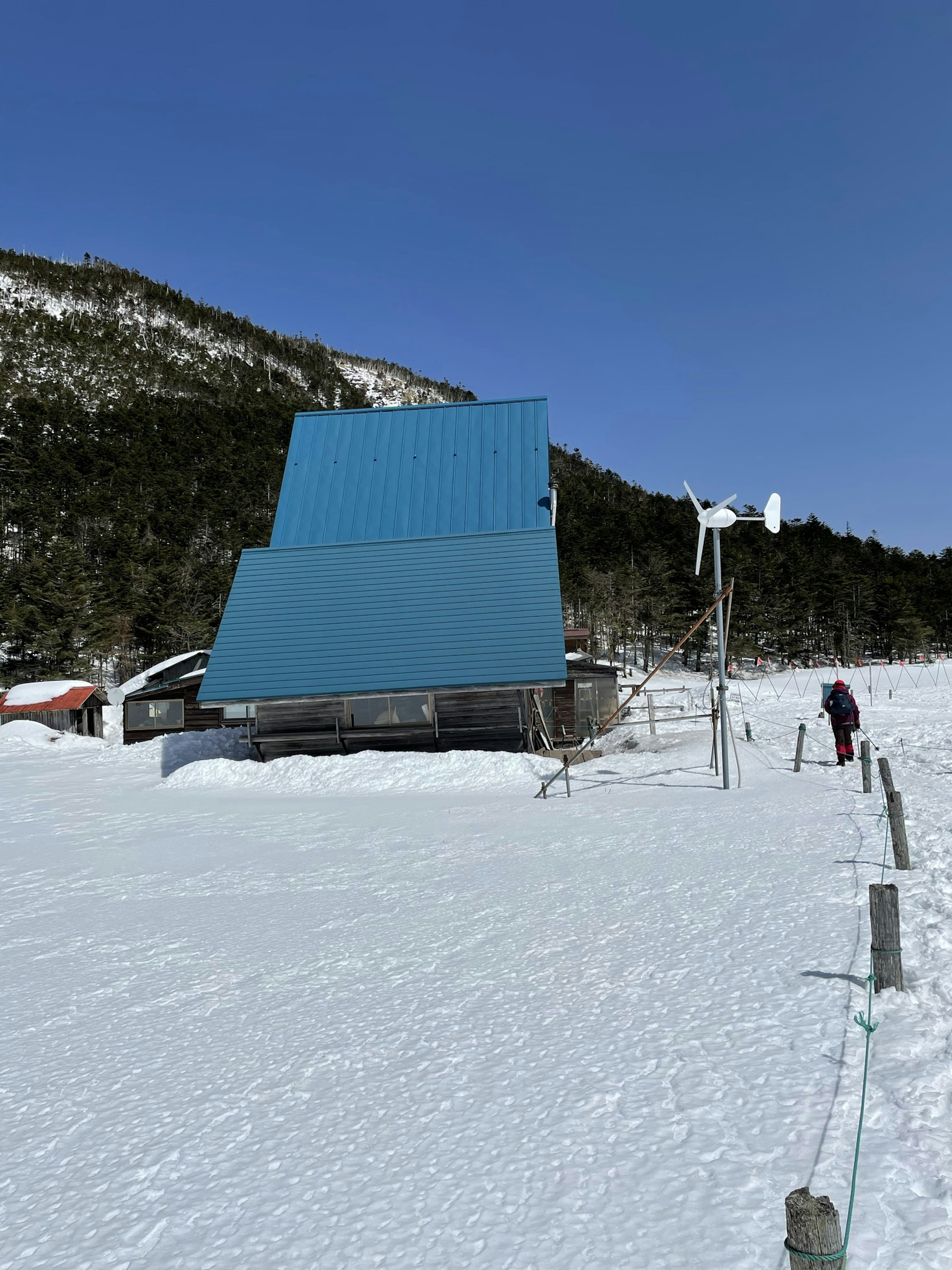 Un bâtiment avec un toit bleu dans un paysage enneigé