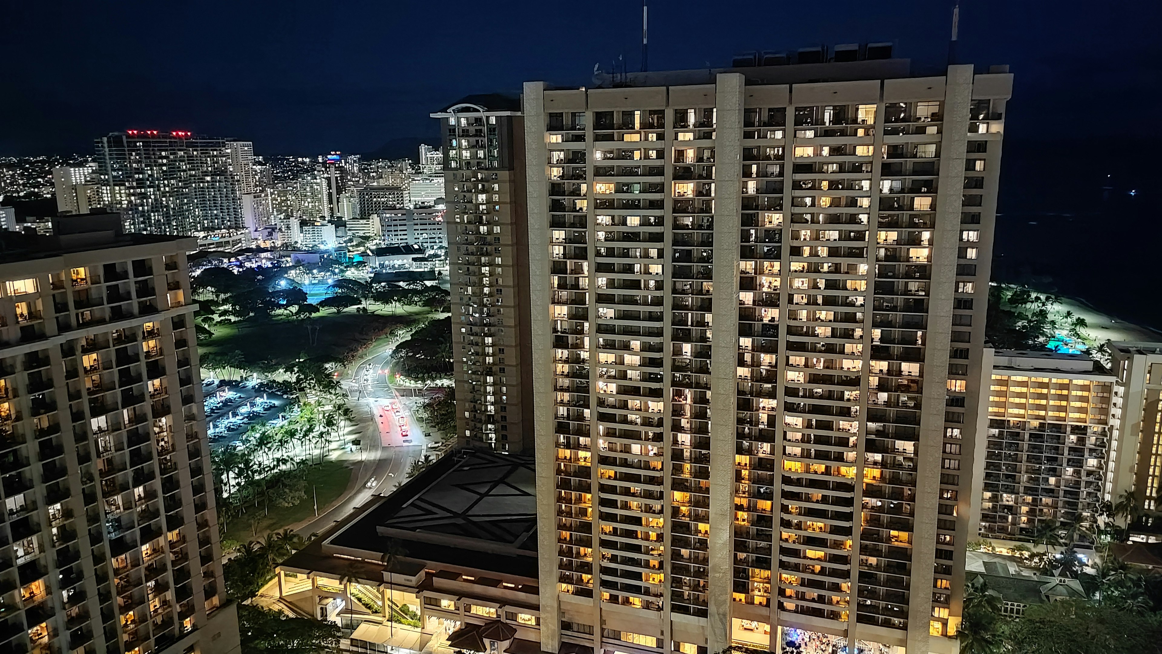 Vista nocturna de edificios altos con ventanas iluminadas