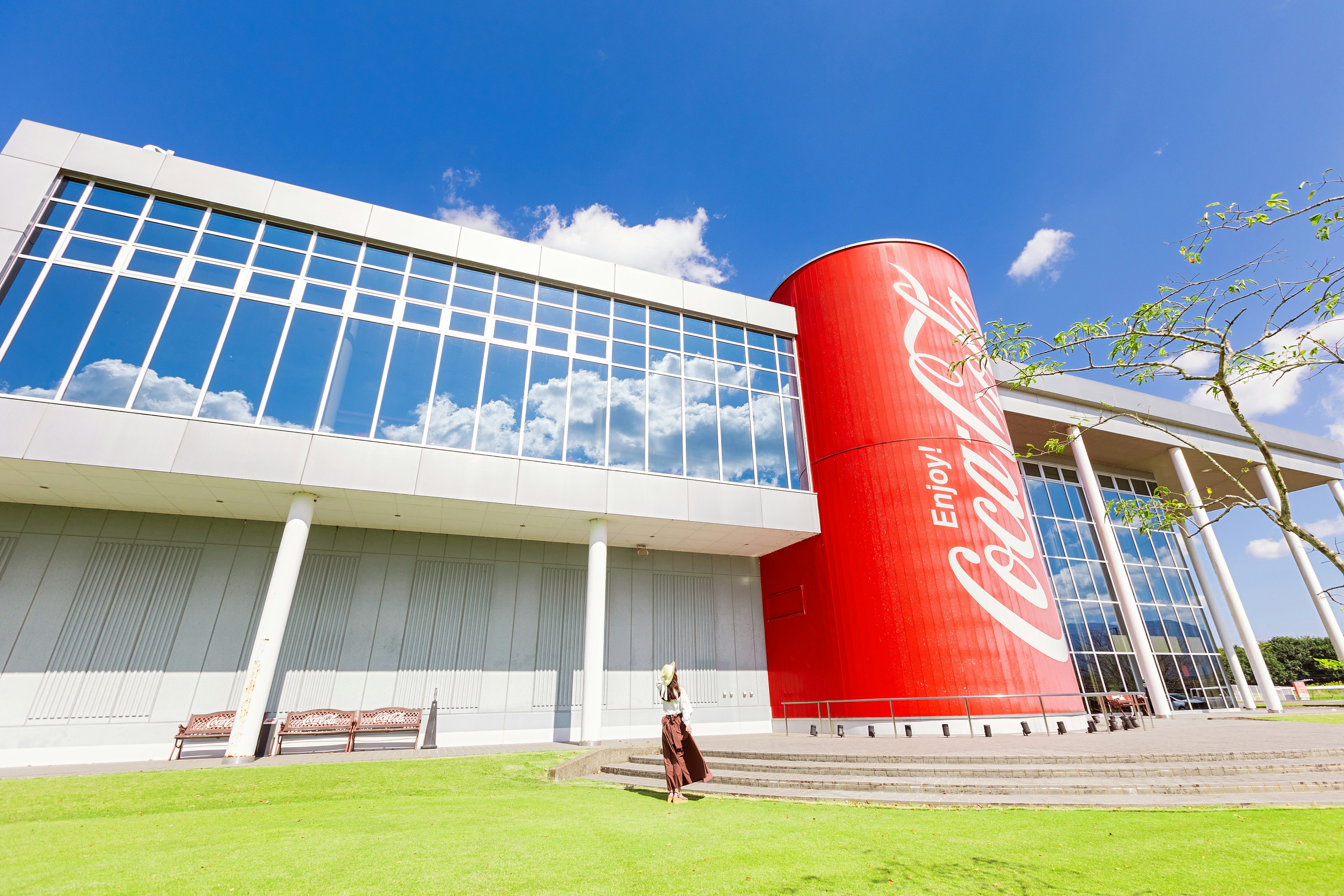 Edificio moderno con un grande cilindro rosso Coca-Cola e facciata in vetro