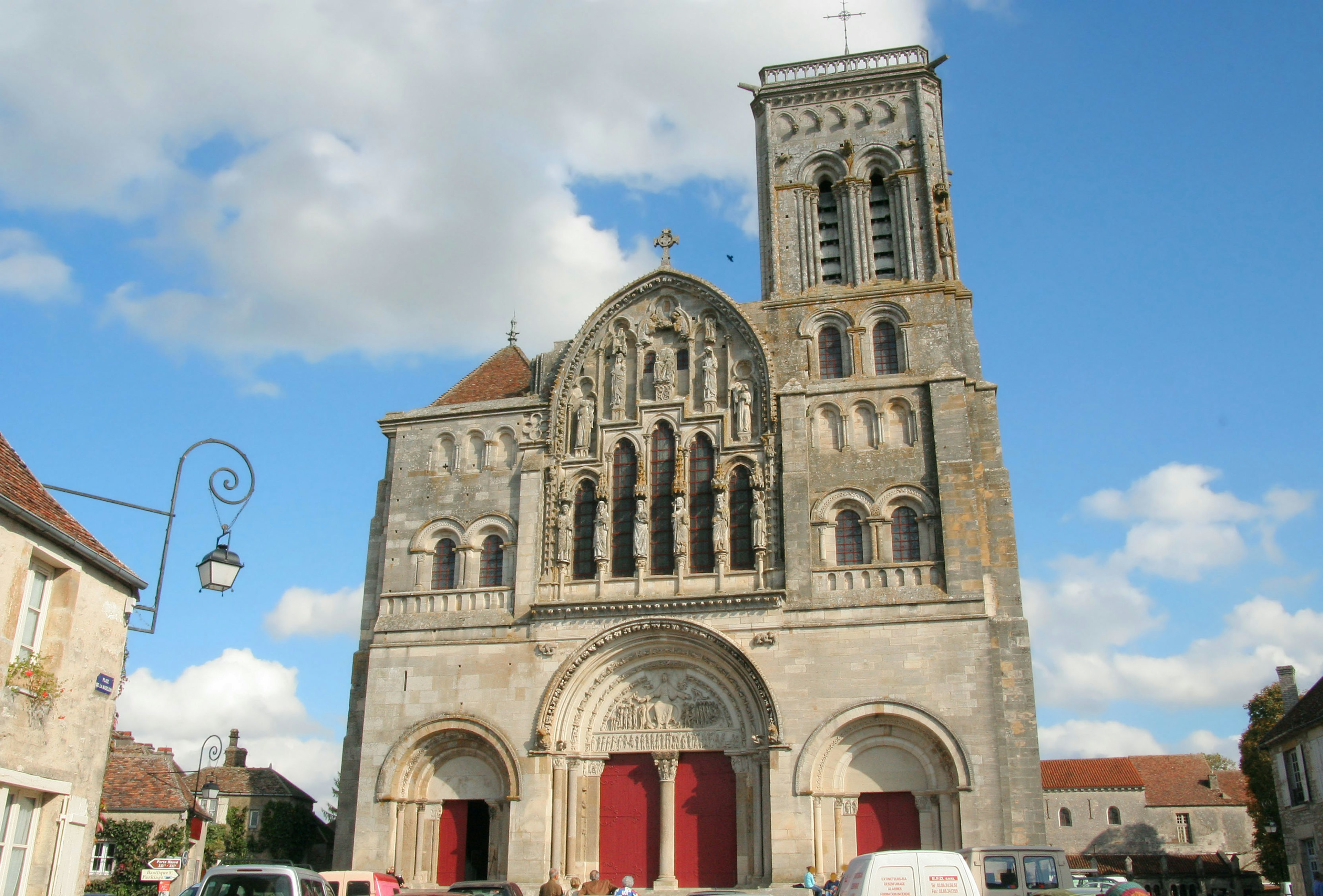 Facciata di chiesa bella con cielo blu e porte rosse