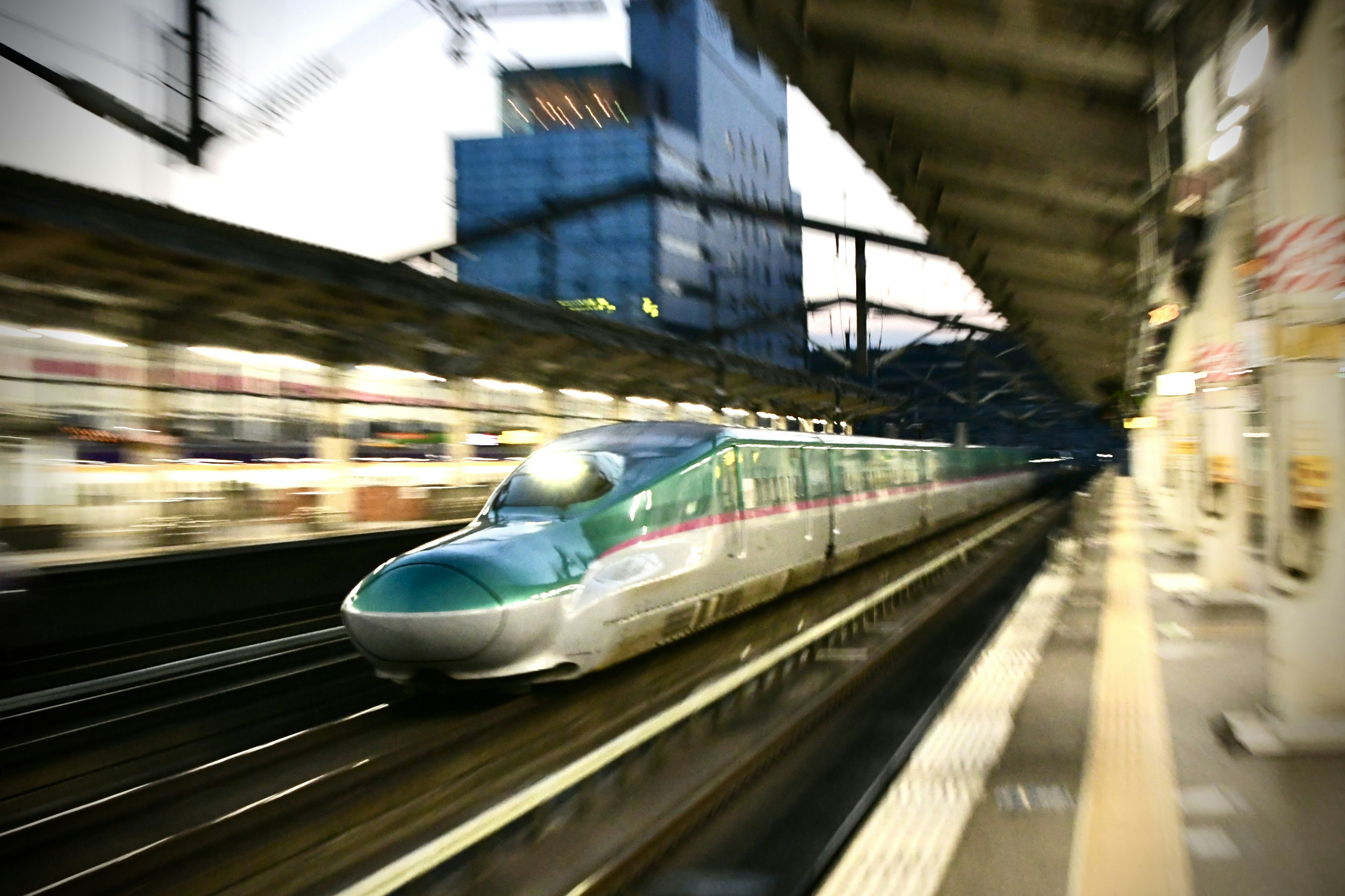 Shinkansen passing through a station with a dynamic motion blur