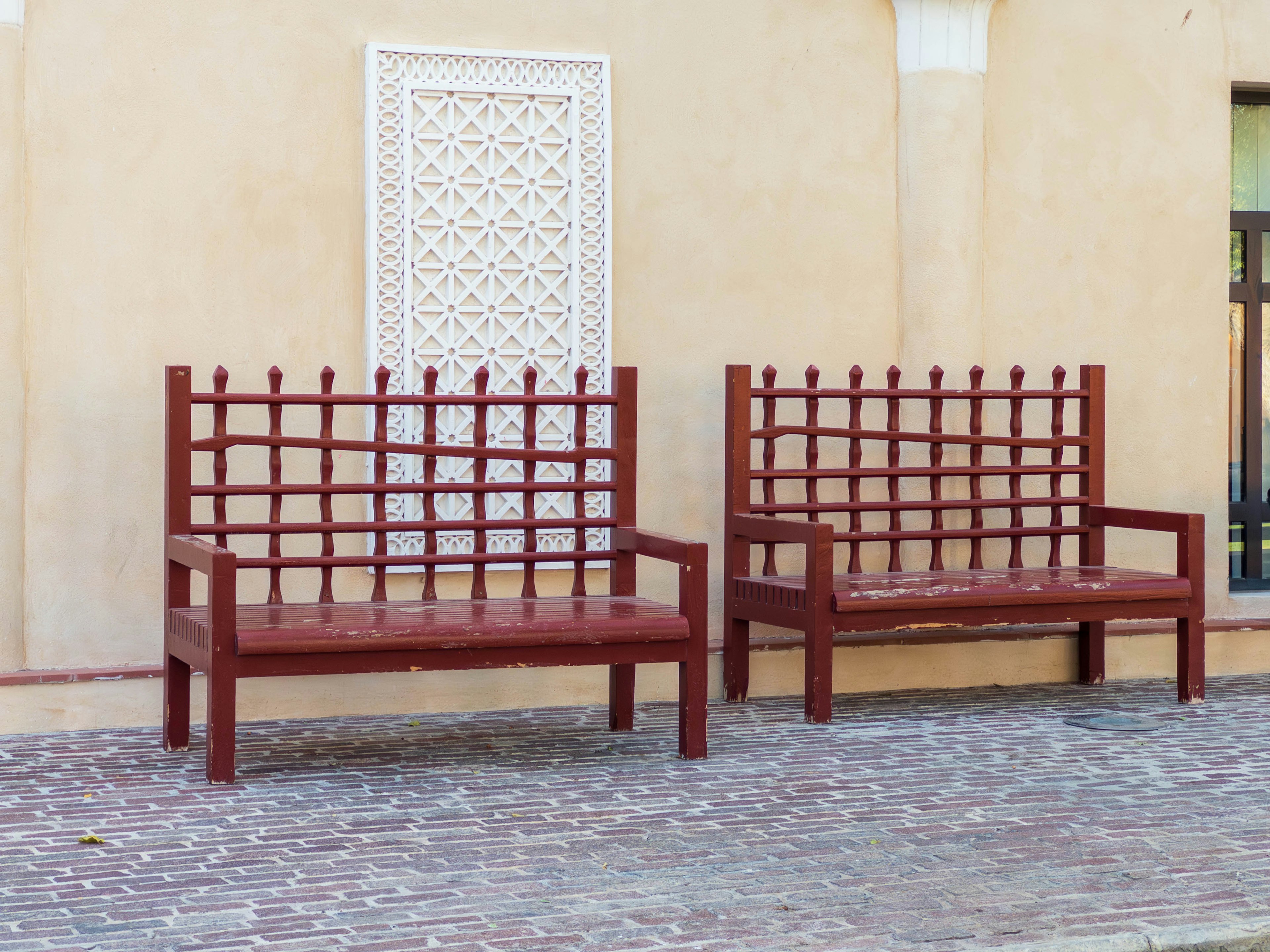 Due panchine rosse davanti a un muro testurizzato