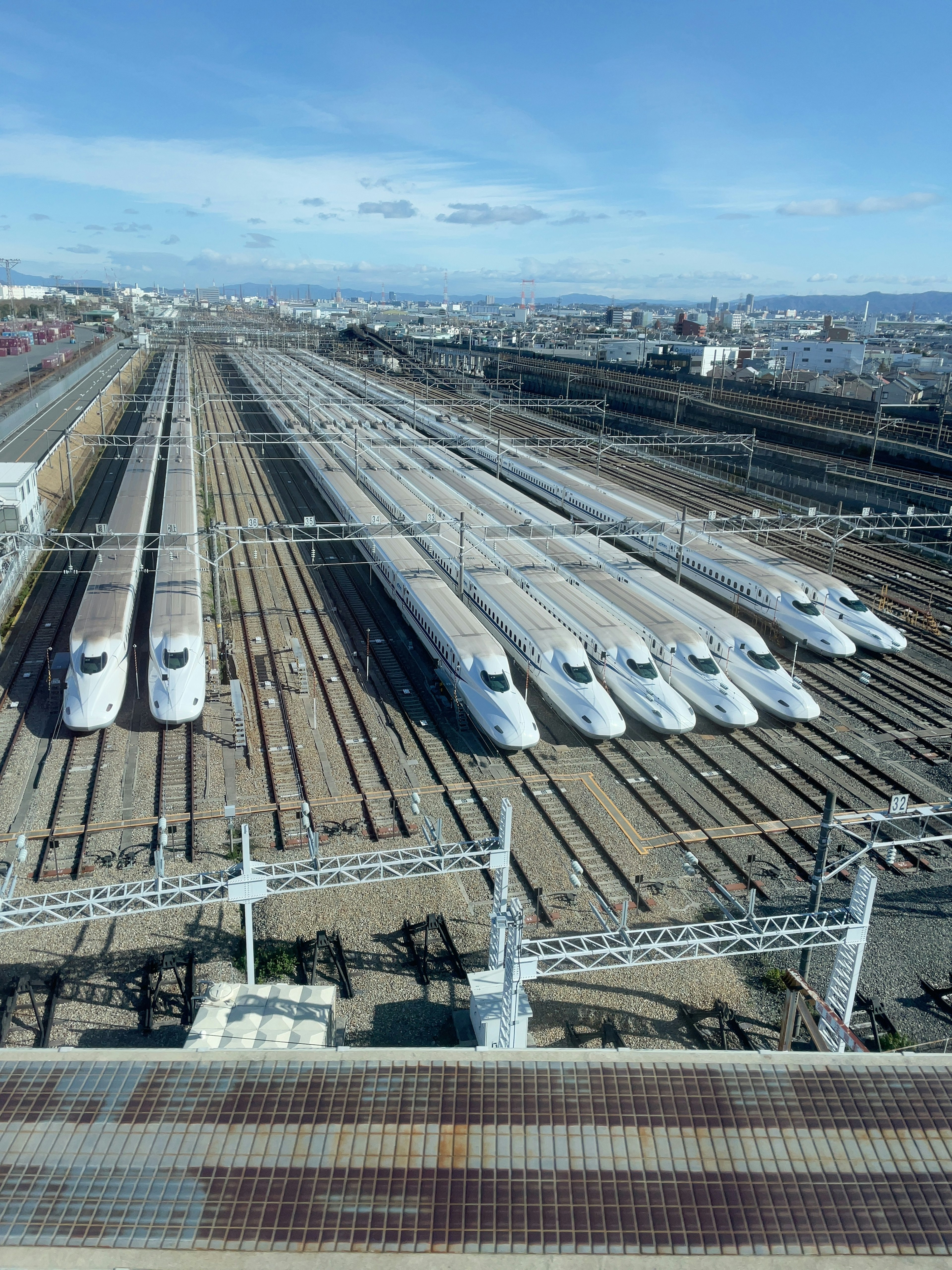 Blick auf mehrere Shinkansen-Züge, die auf den Gleisen stehen