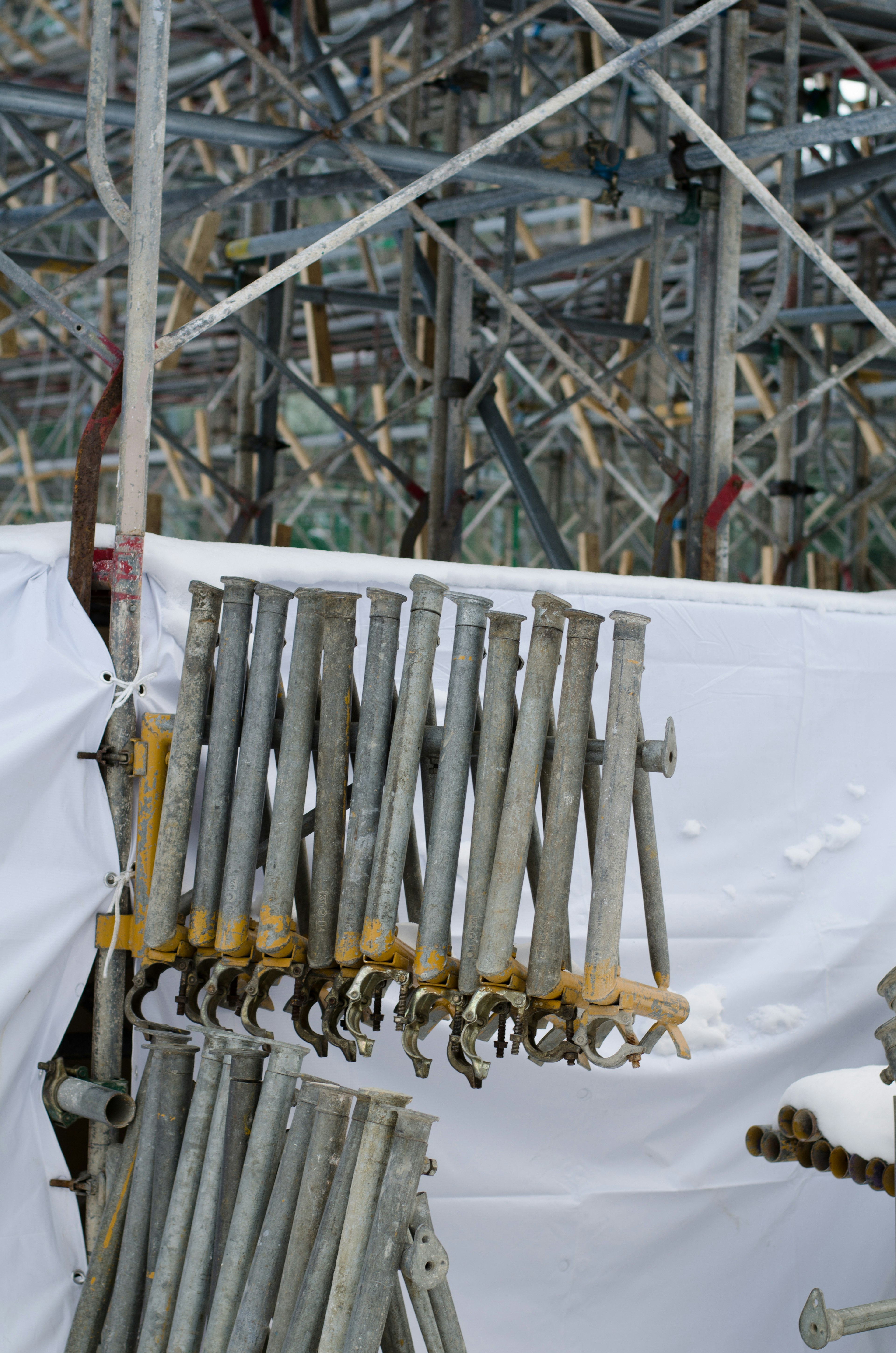 Des tuyaux en acier suspendus sur un site de construction avec un fond blanc