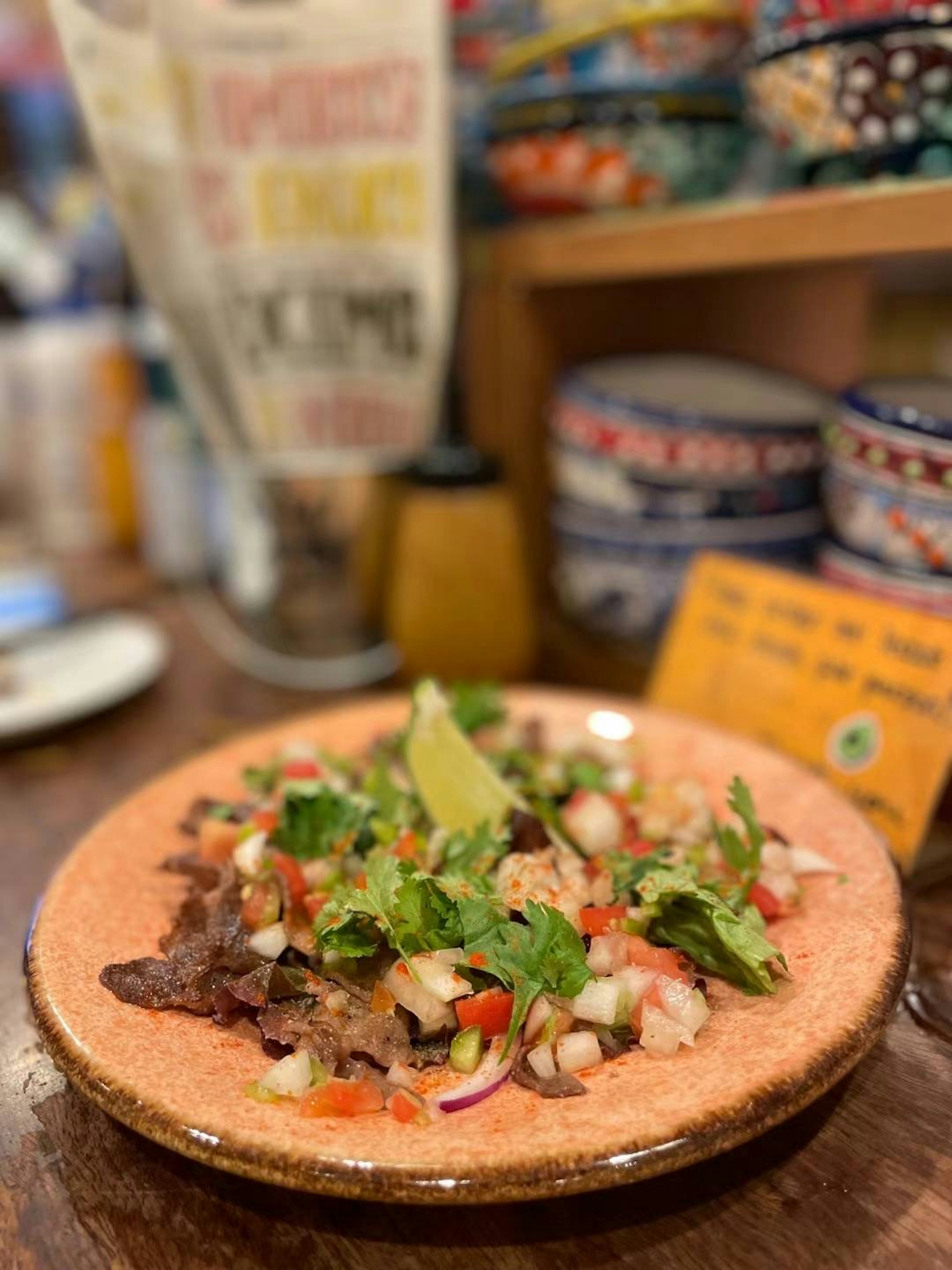 Plated meat dish with fresh salad and lime wedge