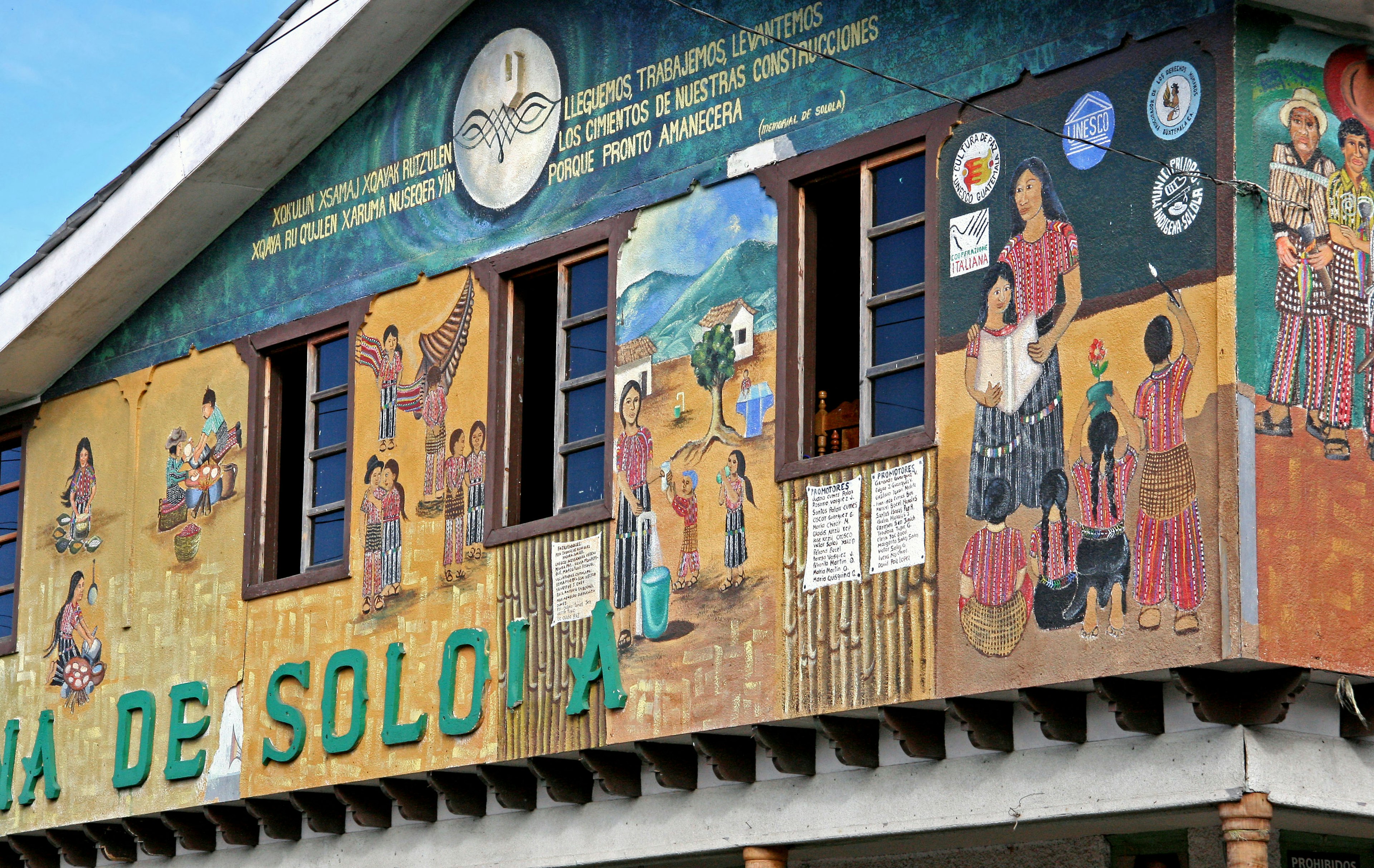 Exterior de un edificio con murales vibrantes y ventanas