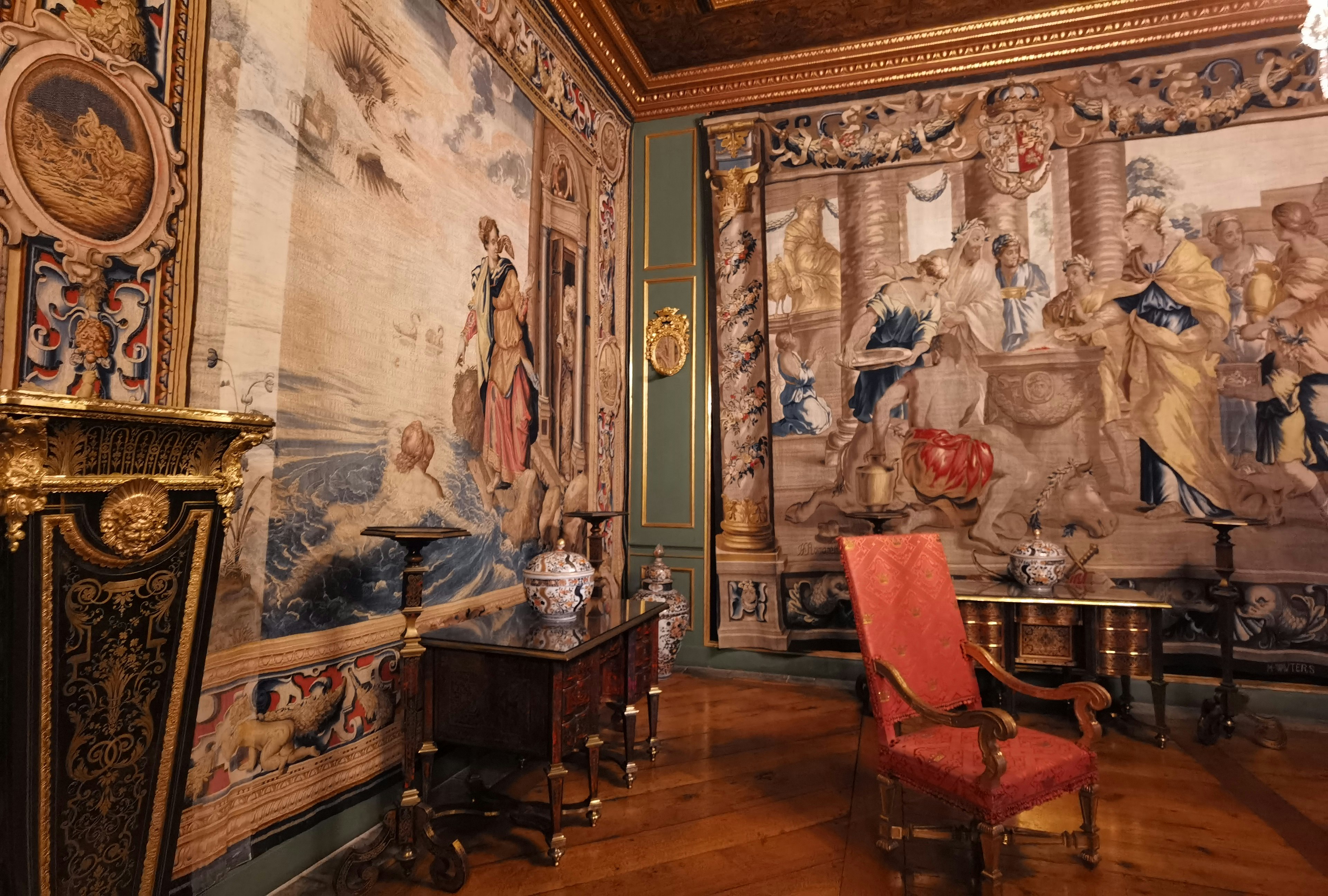 Habitación lujosa con tapices y una silla roja