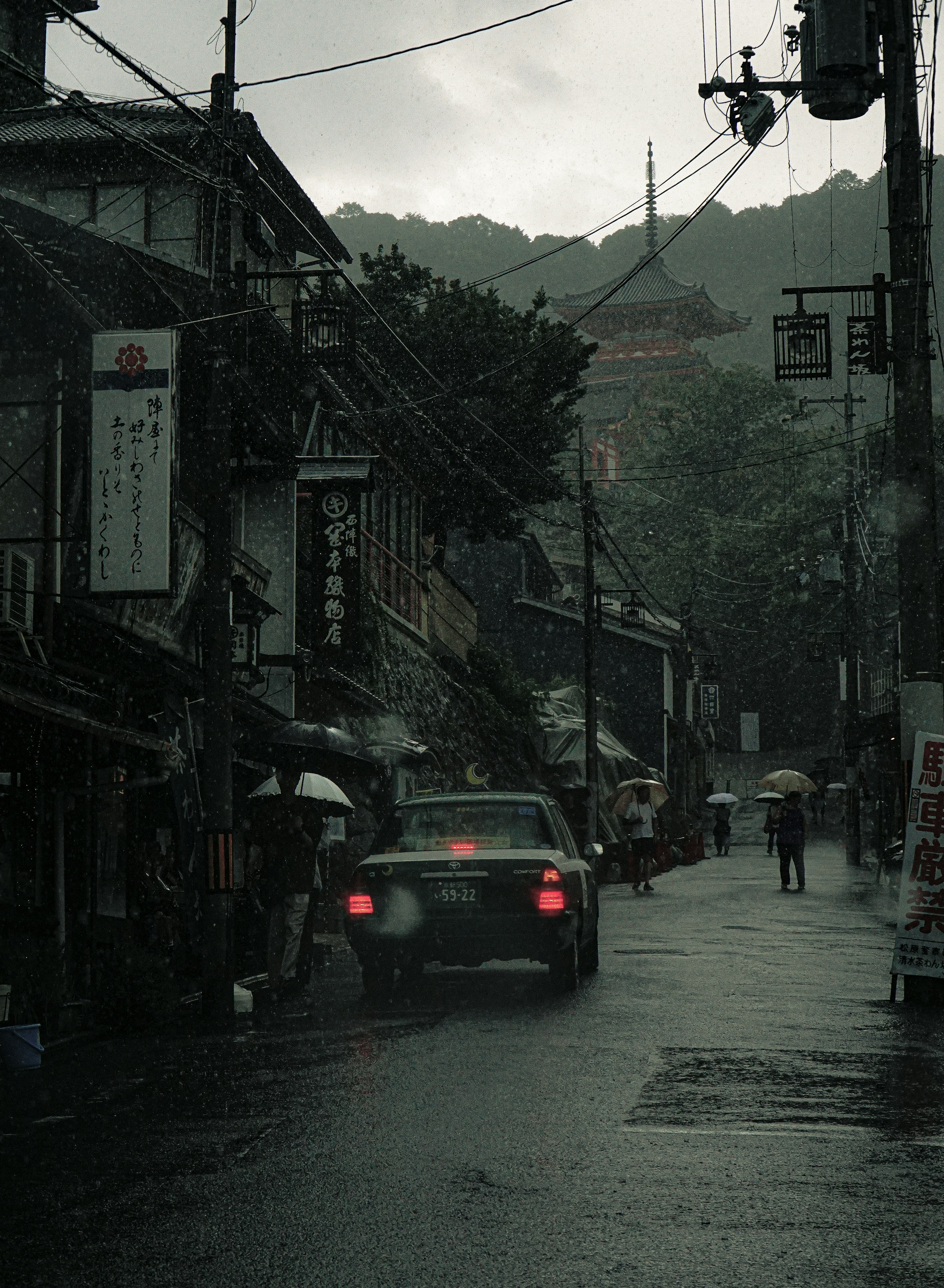 雨の中の静かな街並みと車