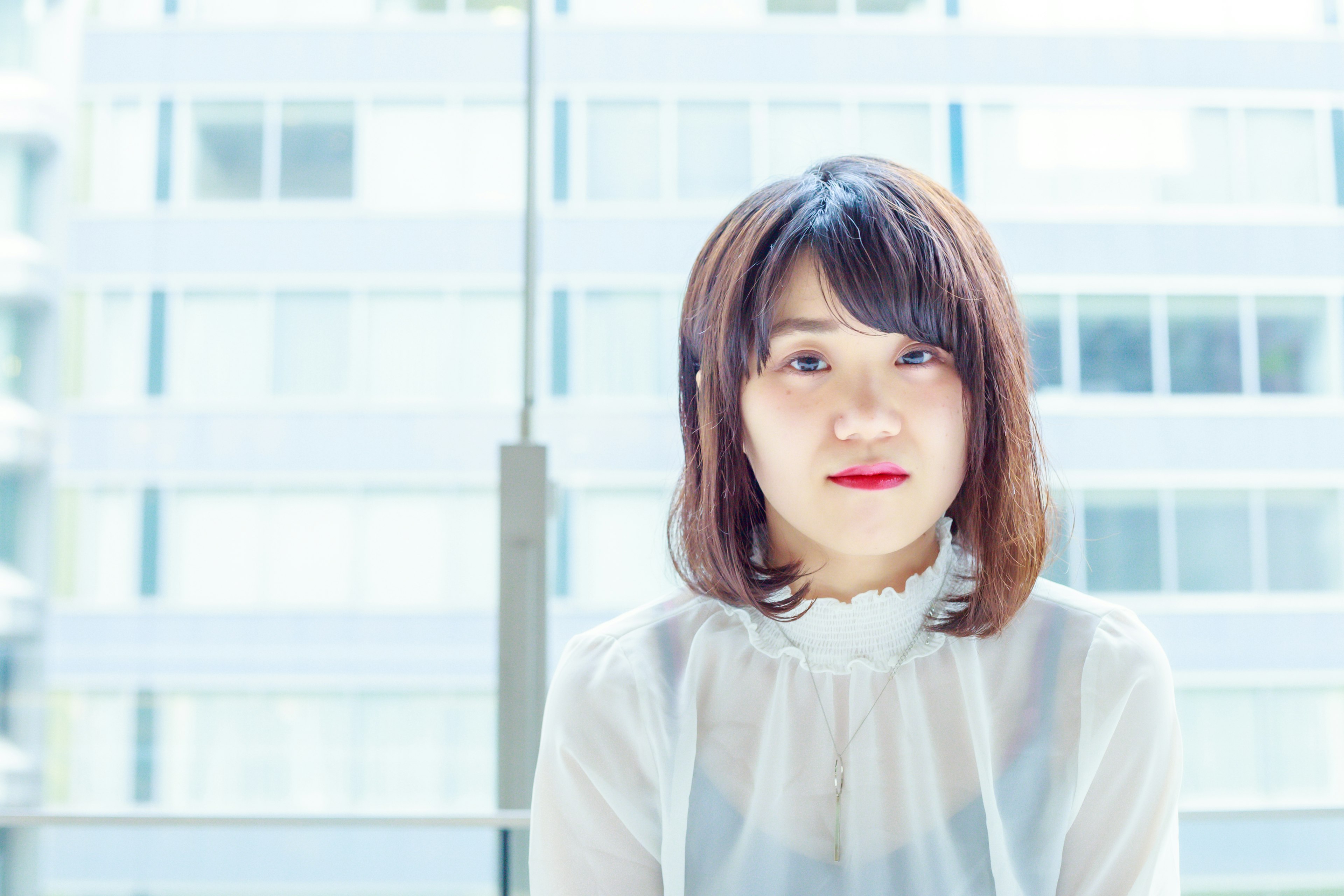 Portrait of a woman sitting in front of bright windows