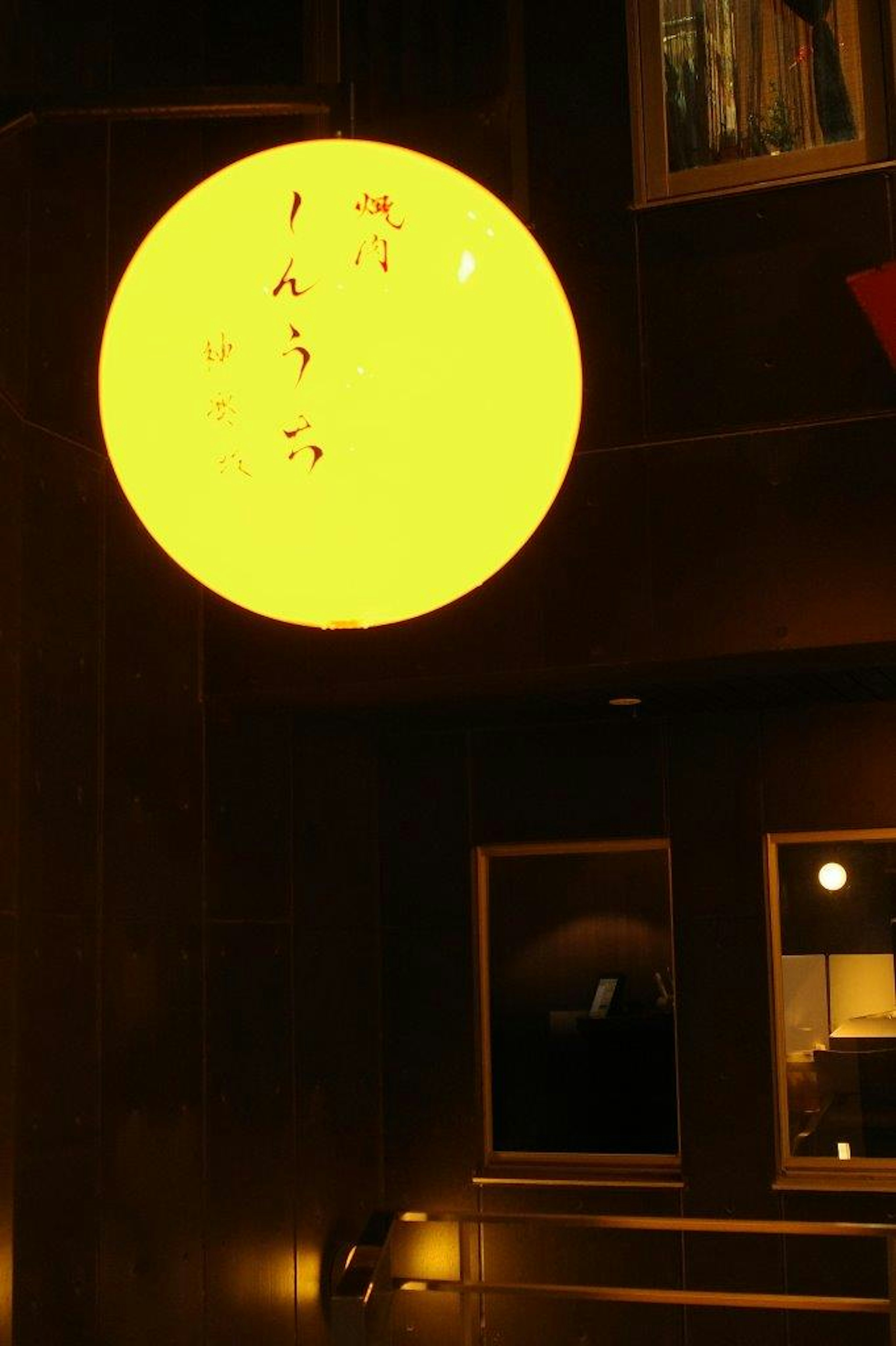 Bright yellow round lantern hanging in an indoor setting