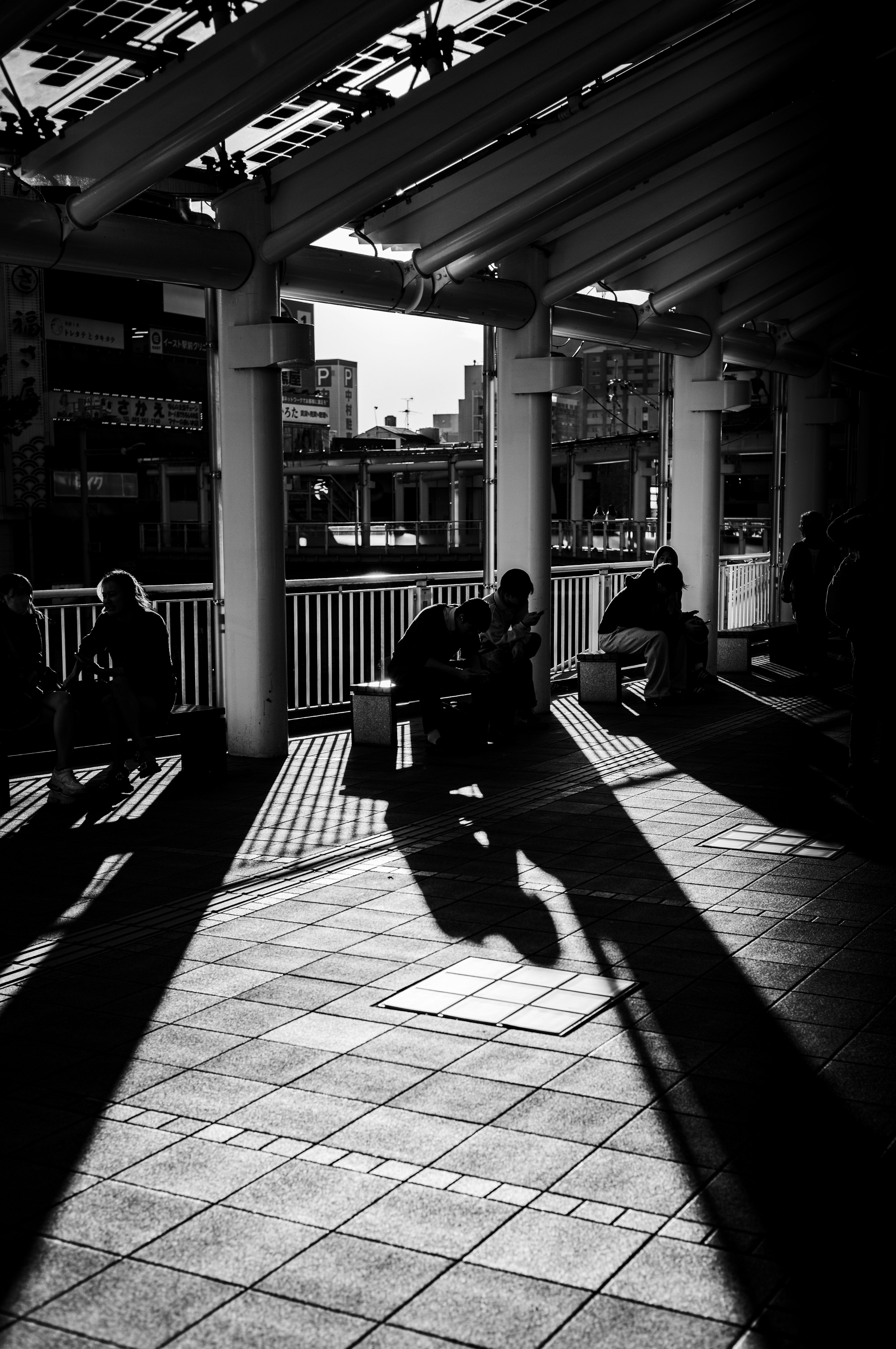 Zone d'attente extérieure avec des ombres noires et blanches qui se croisent