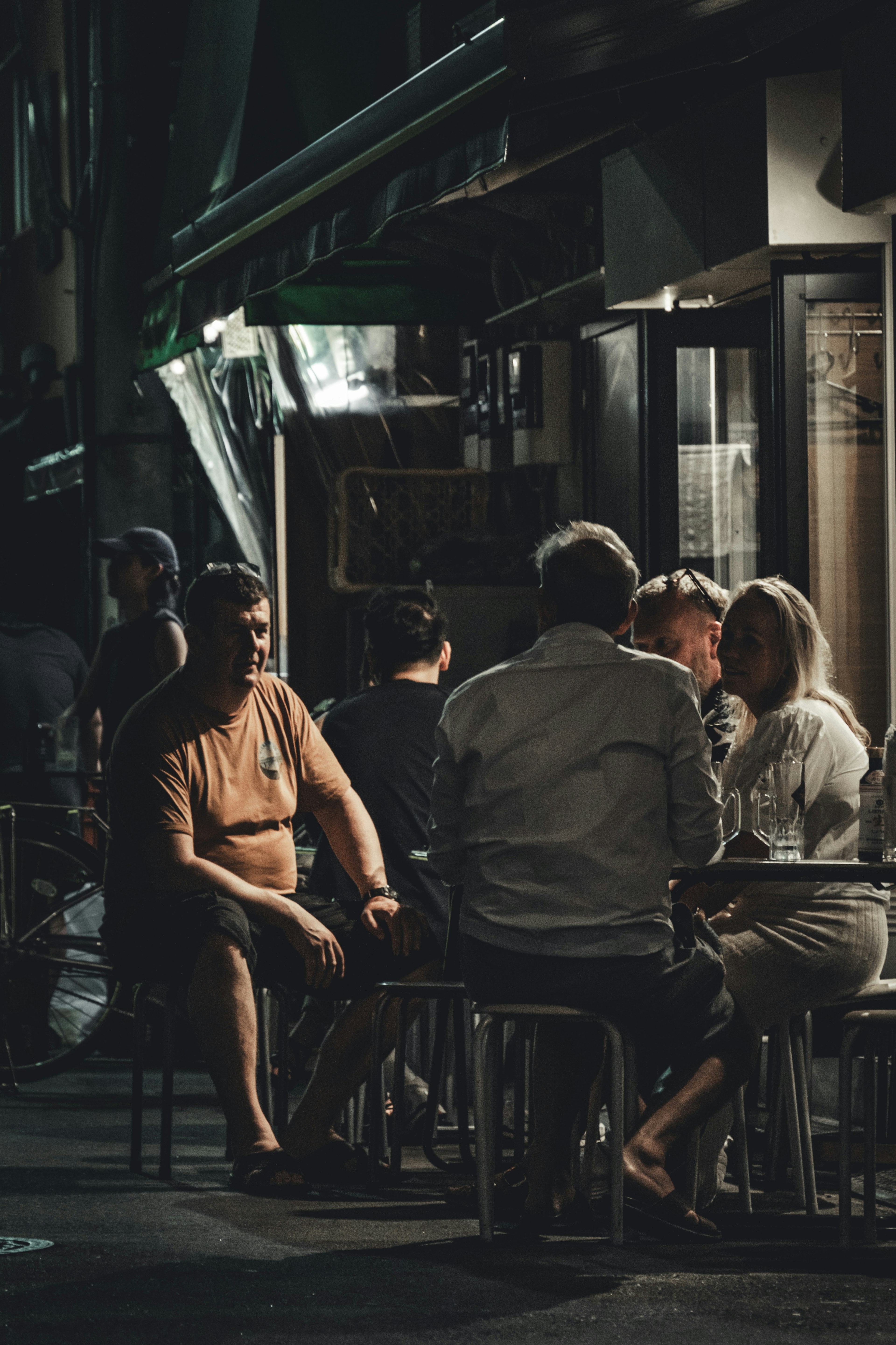 Gruppo di persone sedute in un caffè di notte