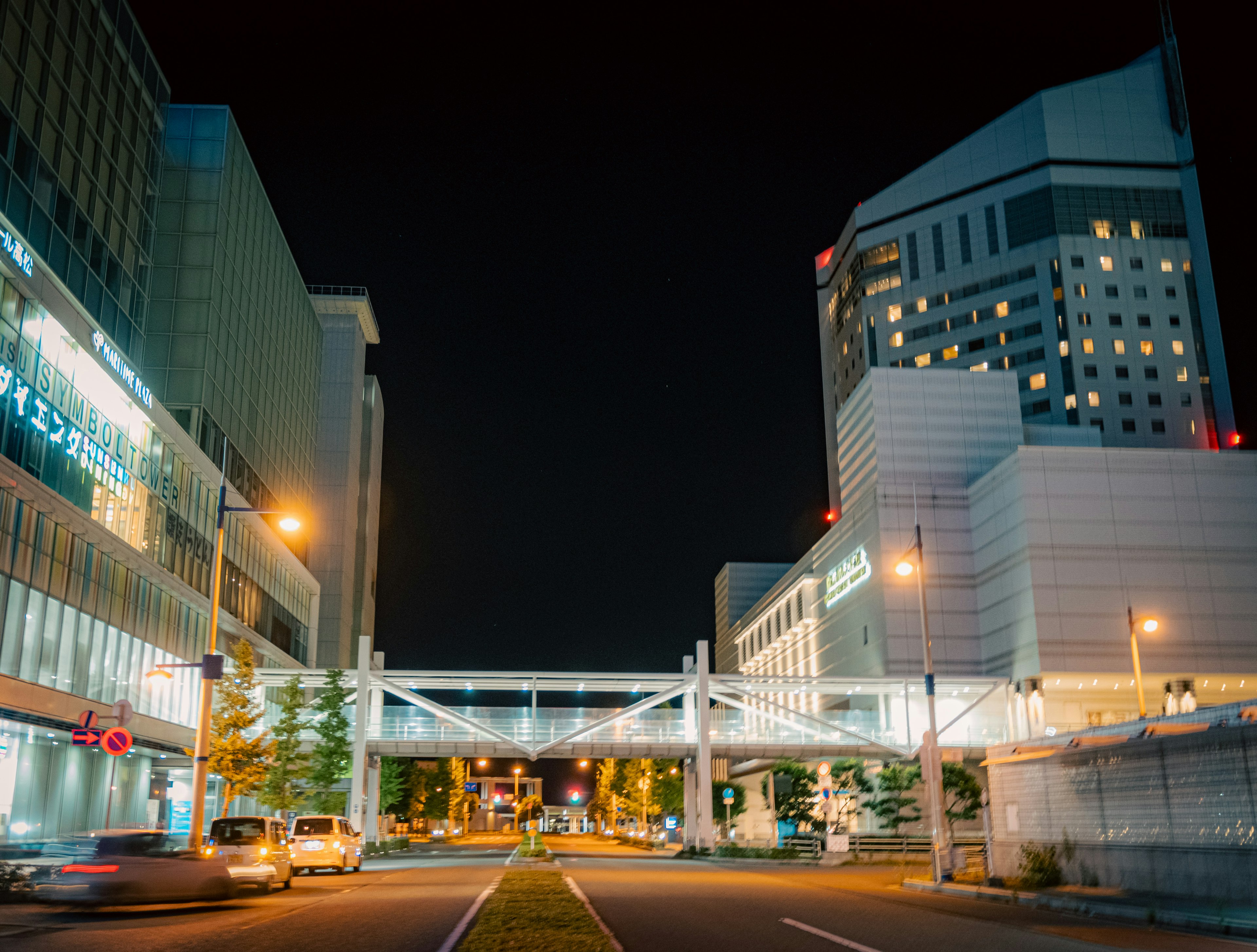 Illuminated buildings and pedestrian bridge in a nighttime urban landscape