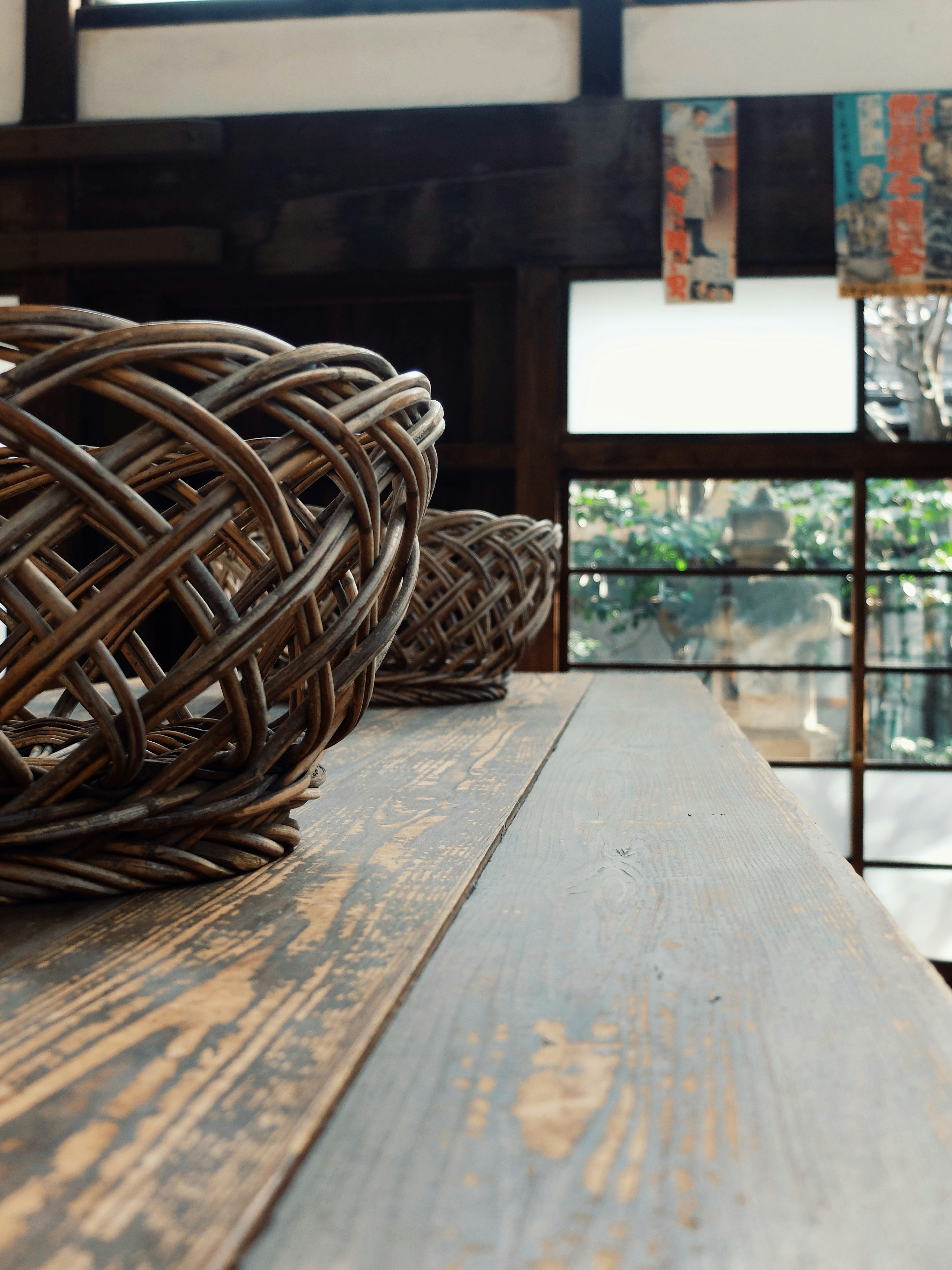 Cestas tejidas sobre una mesa de madera con vista a la ventana