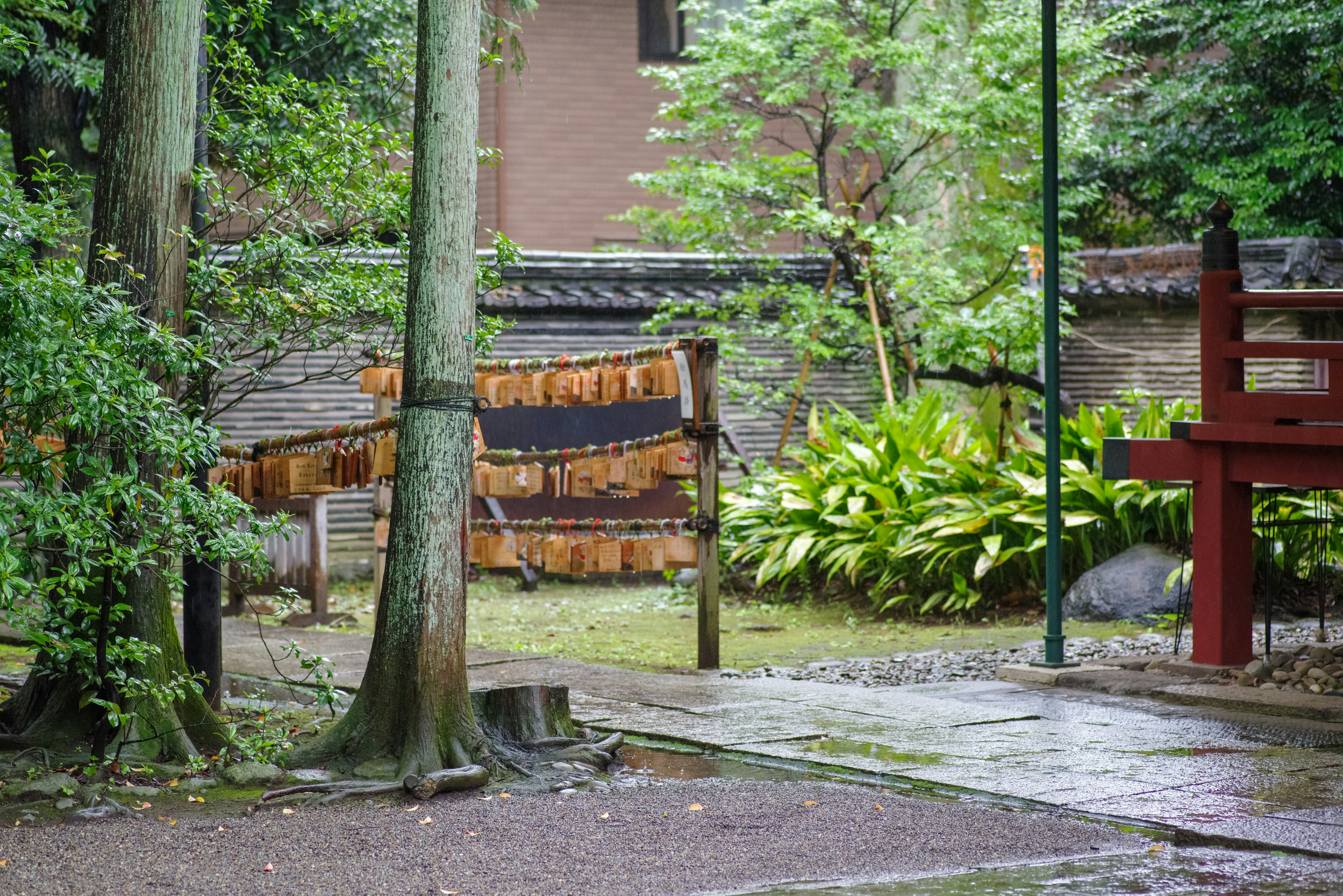 Giardino lussureggiante con alberi e edificio tradizionale sullo sfondo