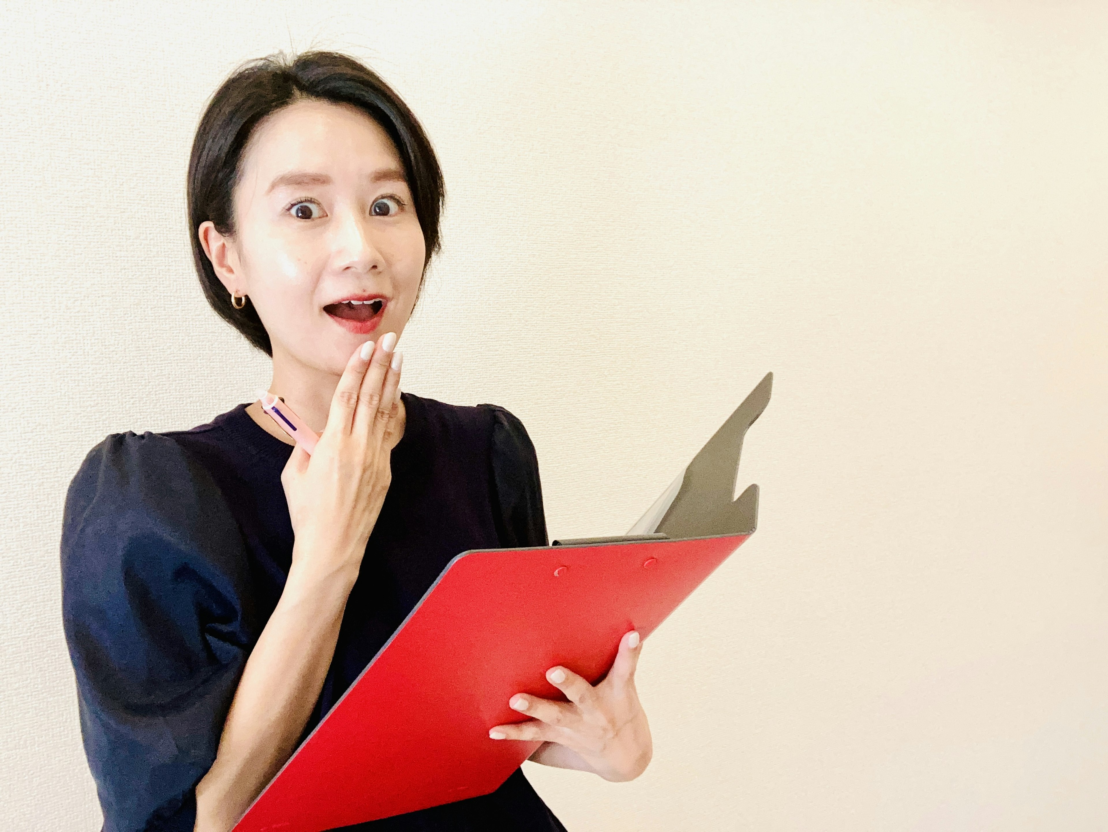 Surprised woman holding a red clipboard