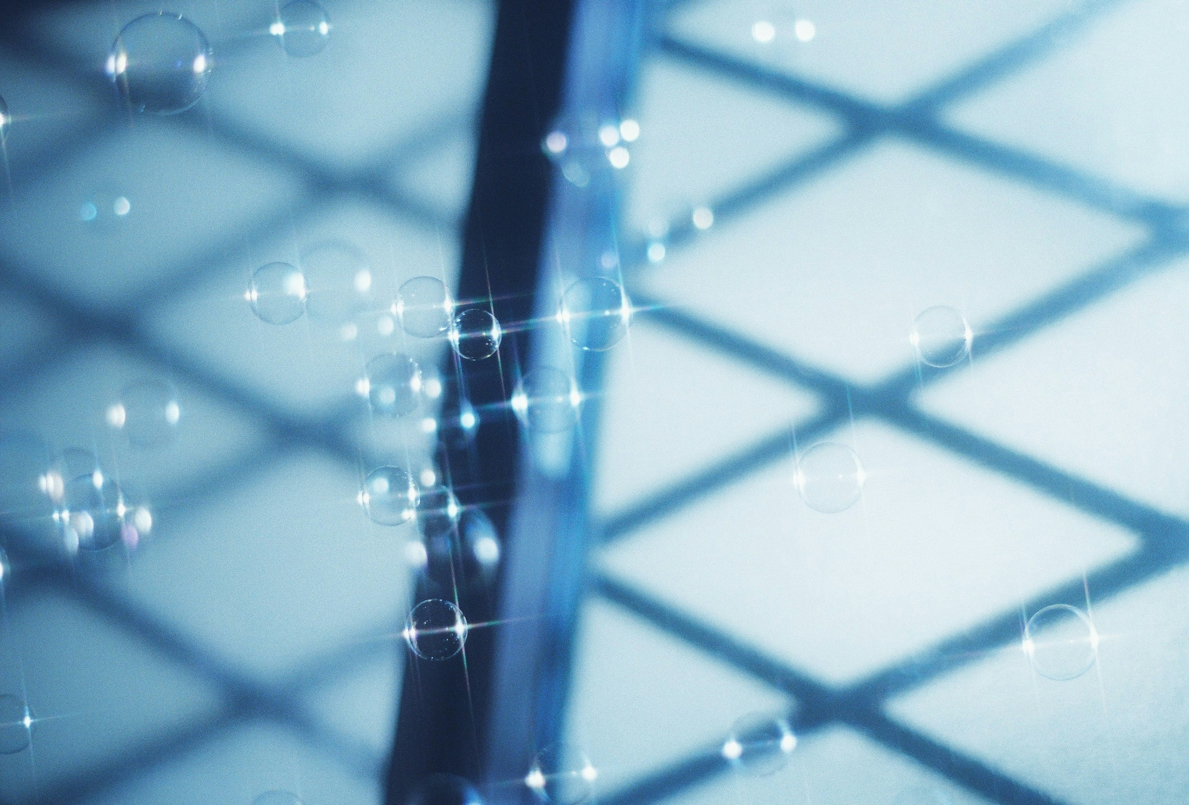 Sparkling bubbles against a blue background with grid pattern shadows