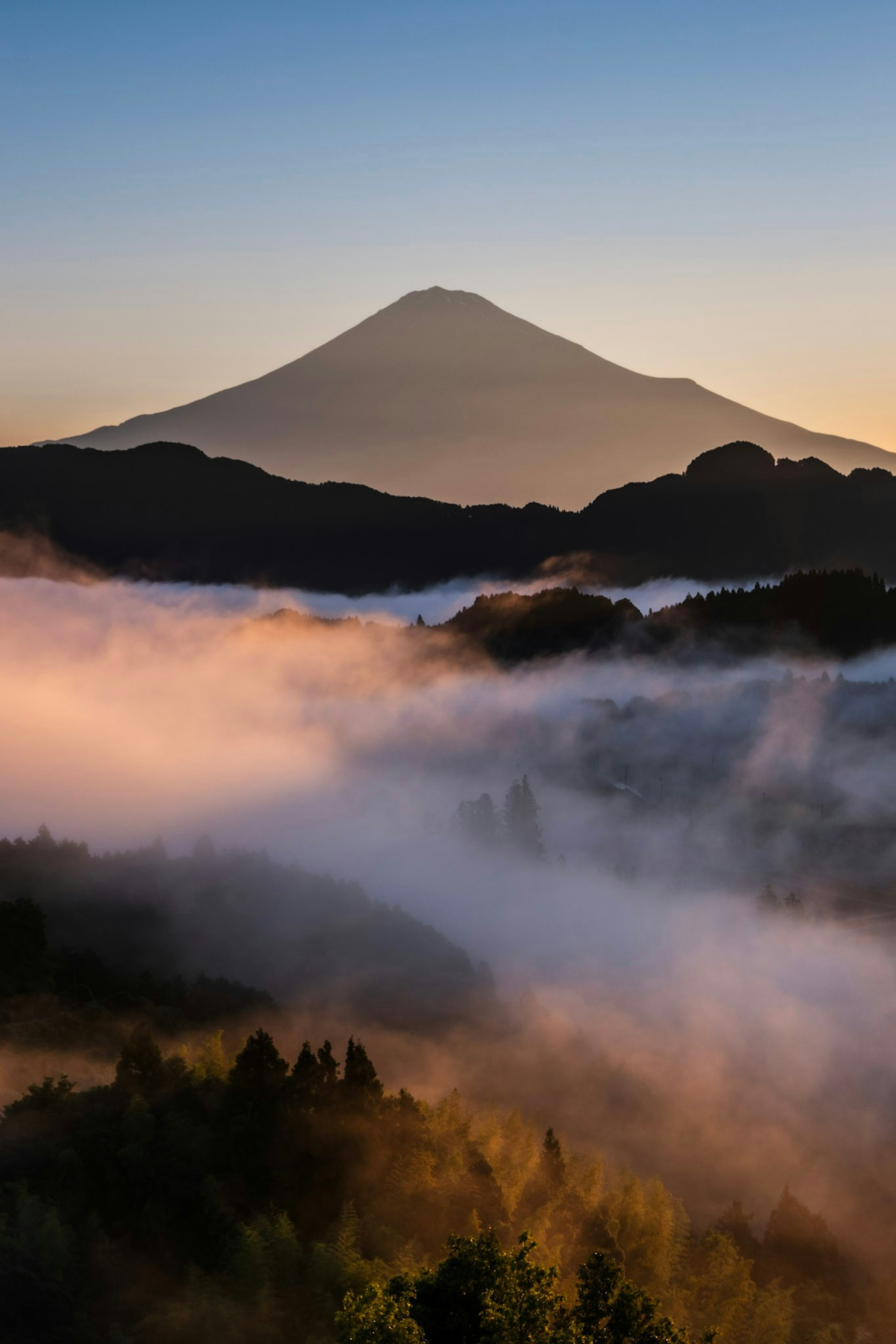 Majestätischer Blick auf den Fuji hinter nebligen Bergen bei Sonnenaufgang