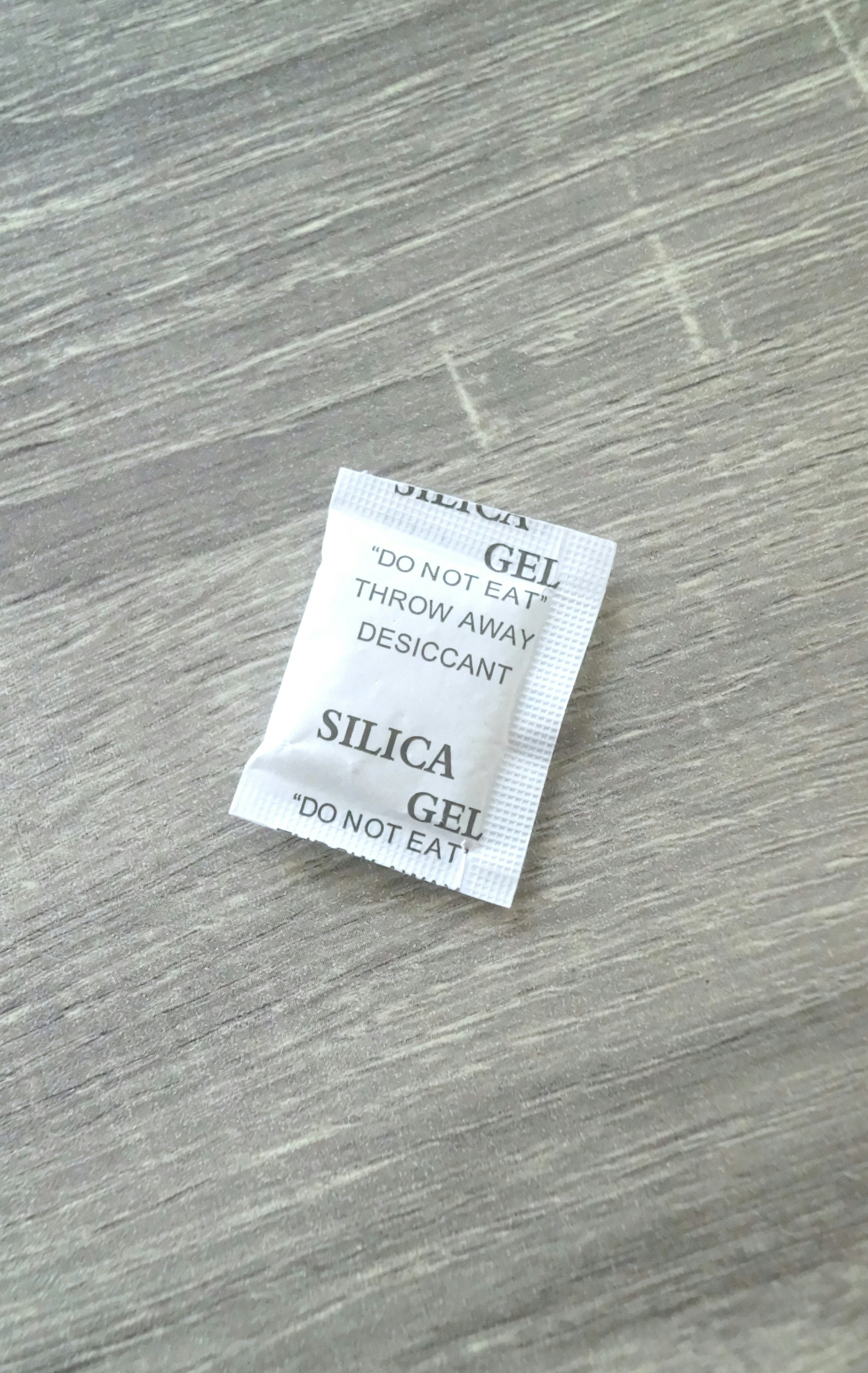 Silica gel packet placed on a wooden surface