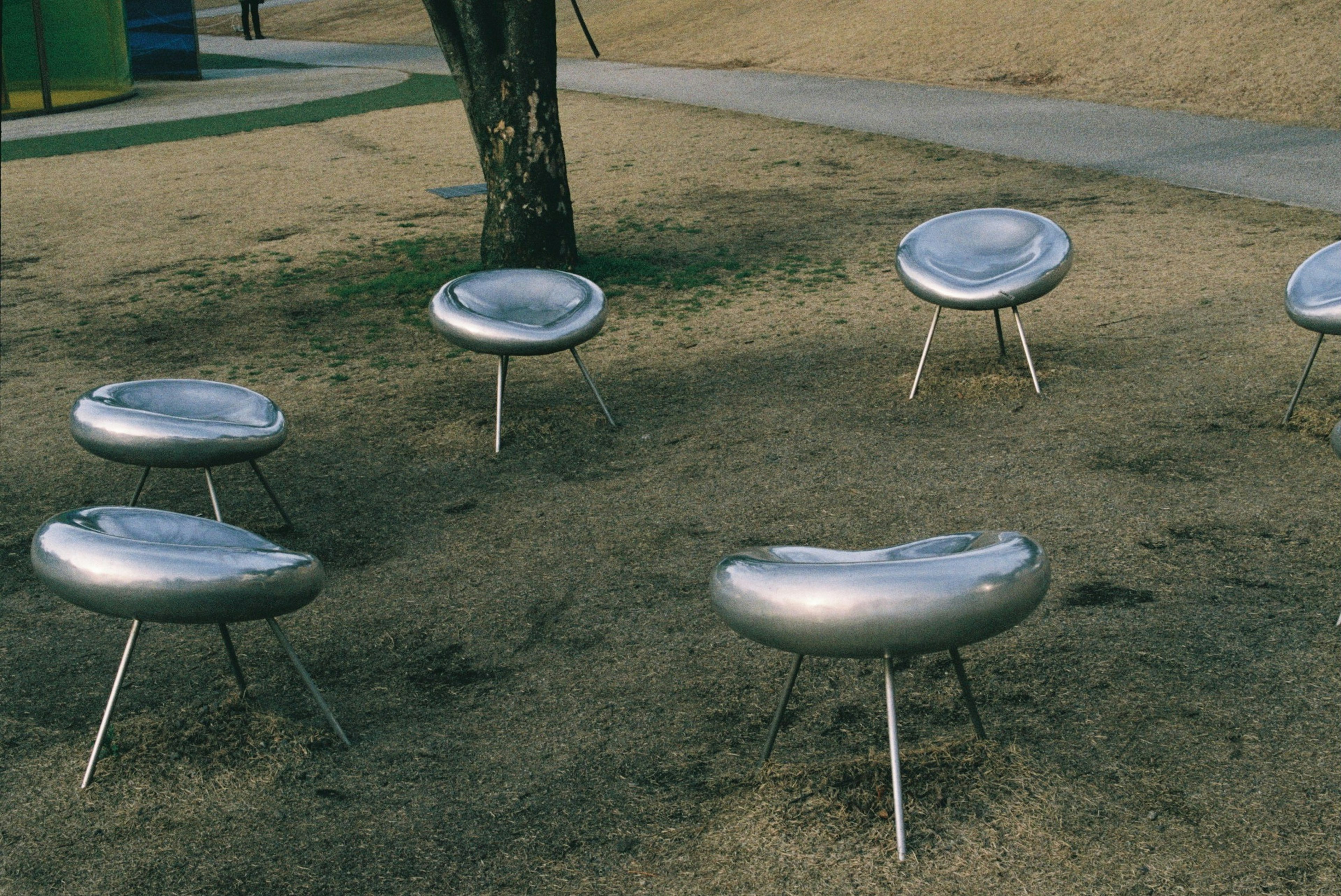 Chaises argentées uniques disposées sur un sol herbeux