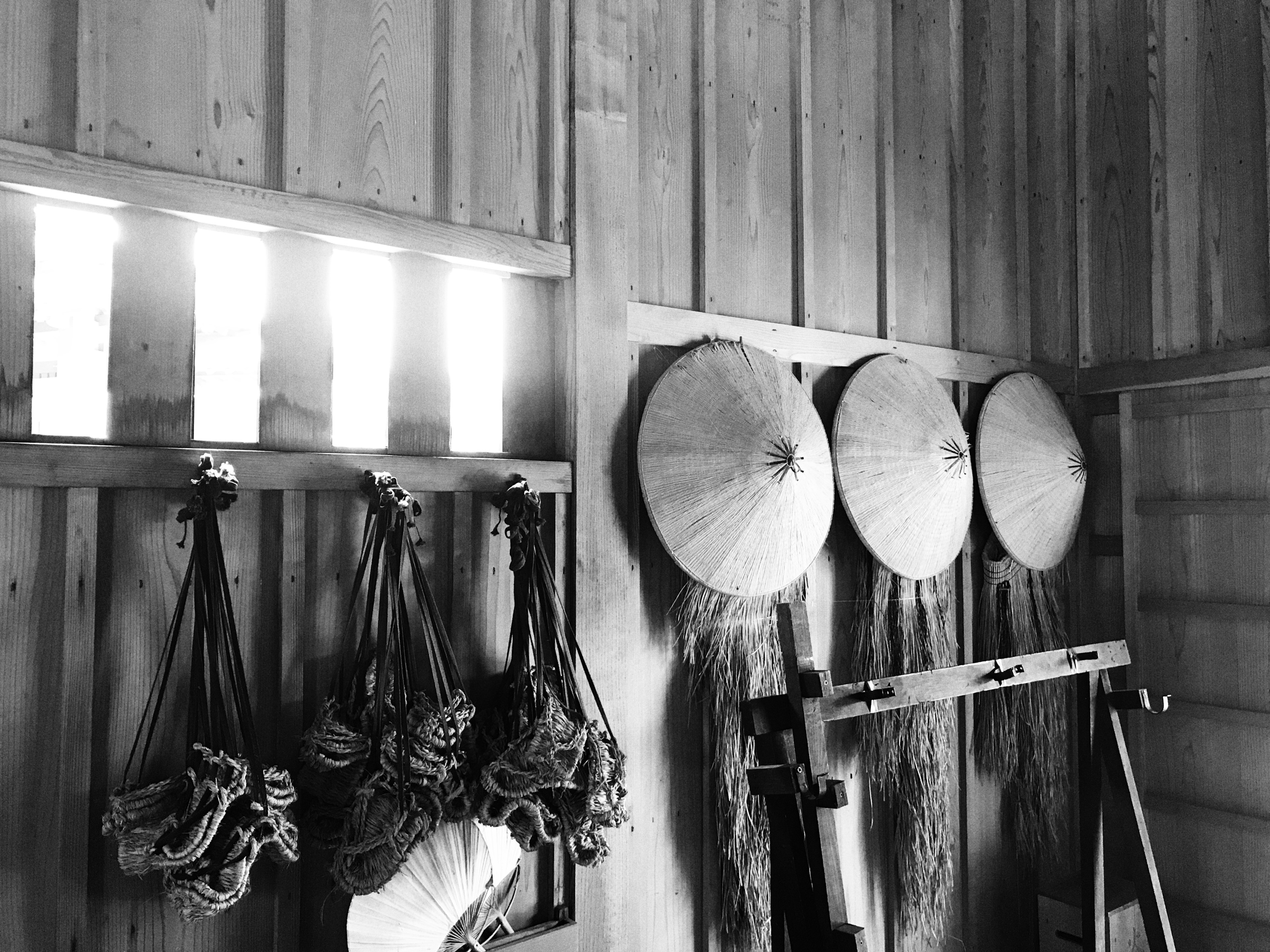 Interior con sombreros tradicionales y herramientas colgadas en paredes de madera