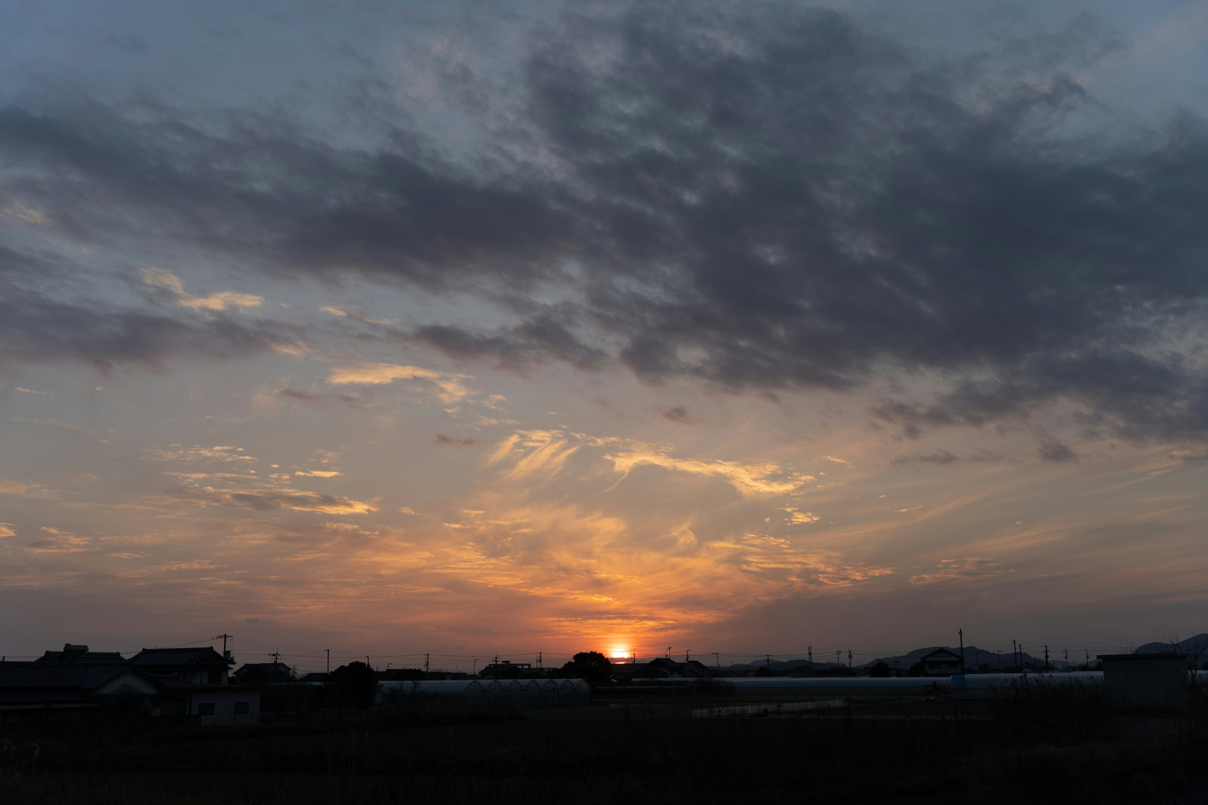 夕焼けの空に浮かぶ雲と沈む太陽