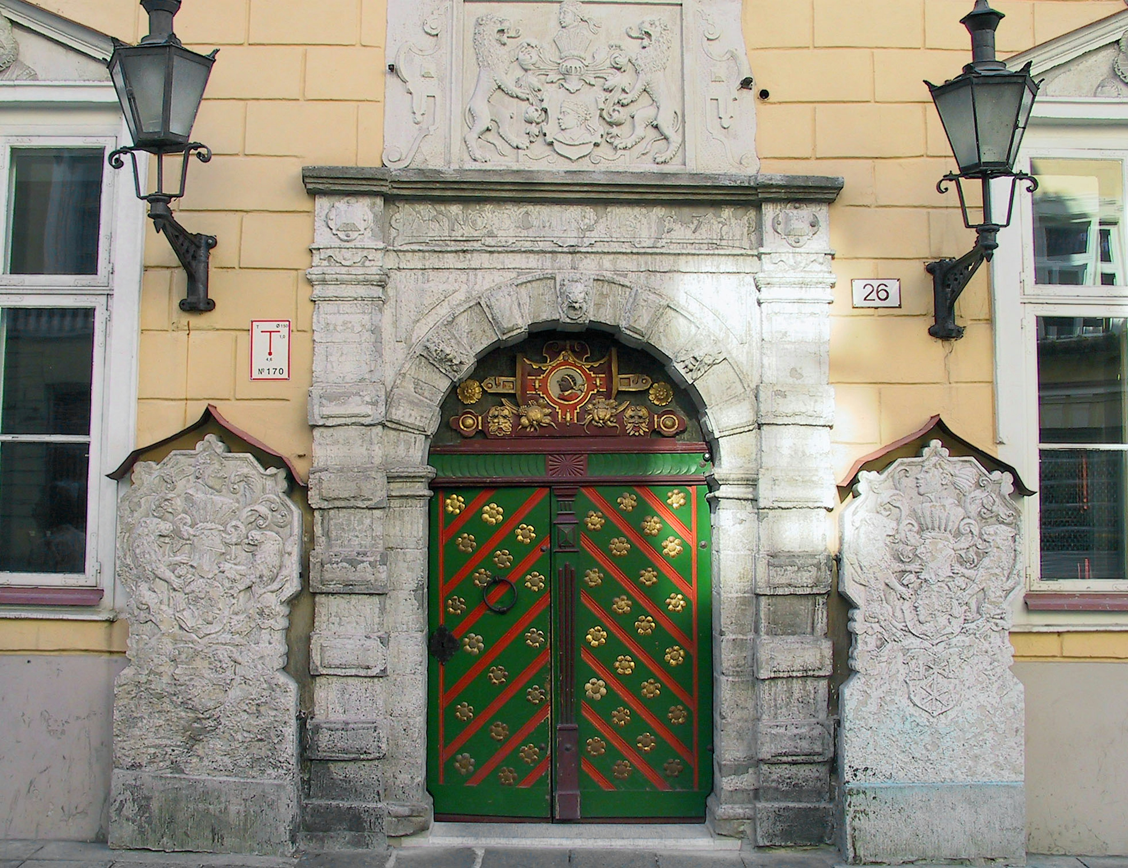 Fachada de un edificio histórico con una puerta decorativa verde y roja