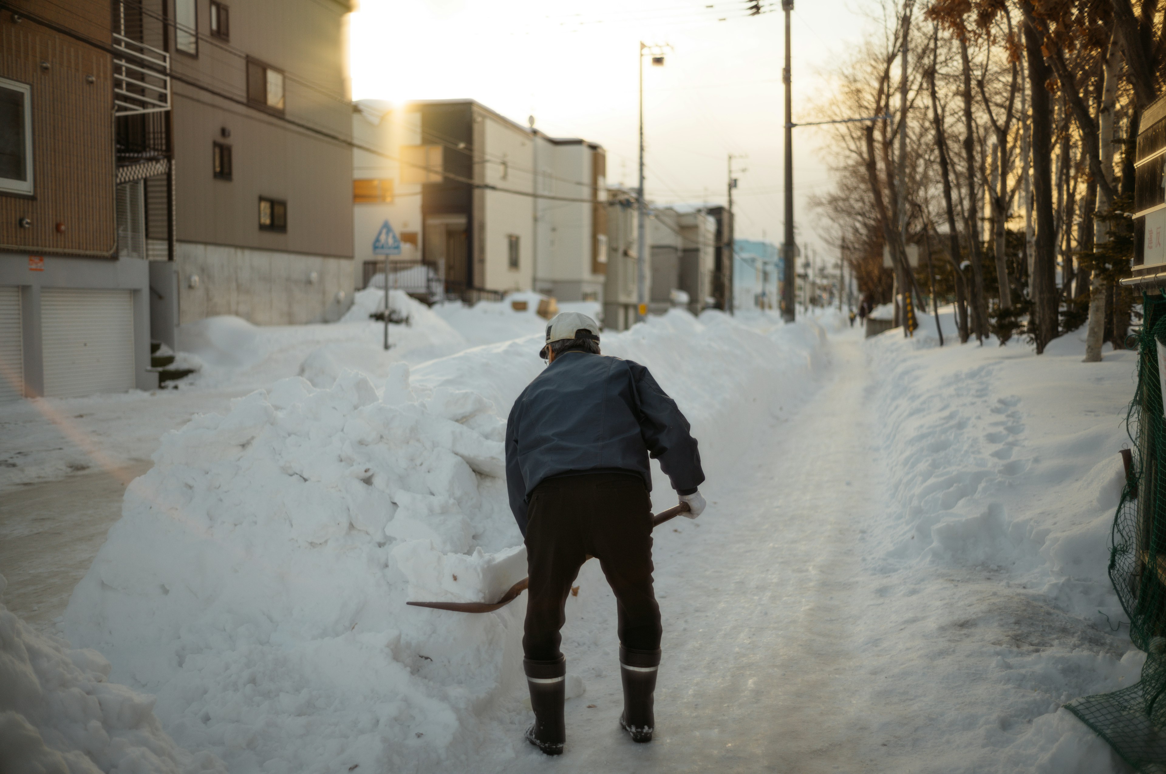 Uomo che spala la neve su una strada coperta di neve