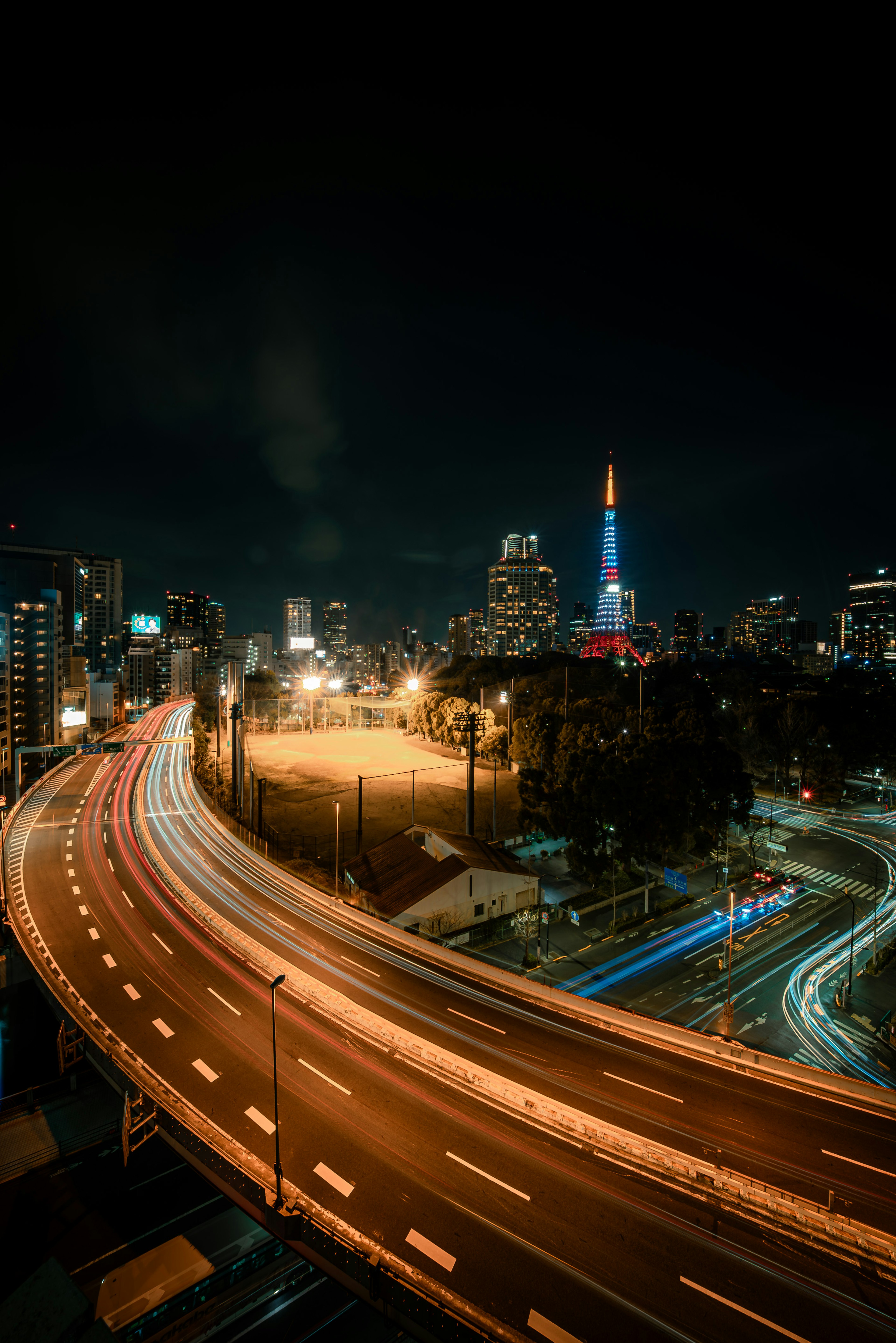 夜の東京の街並みと東京タワーを背景にした高速道路の風景