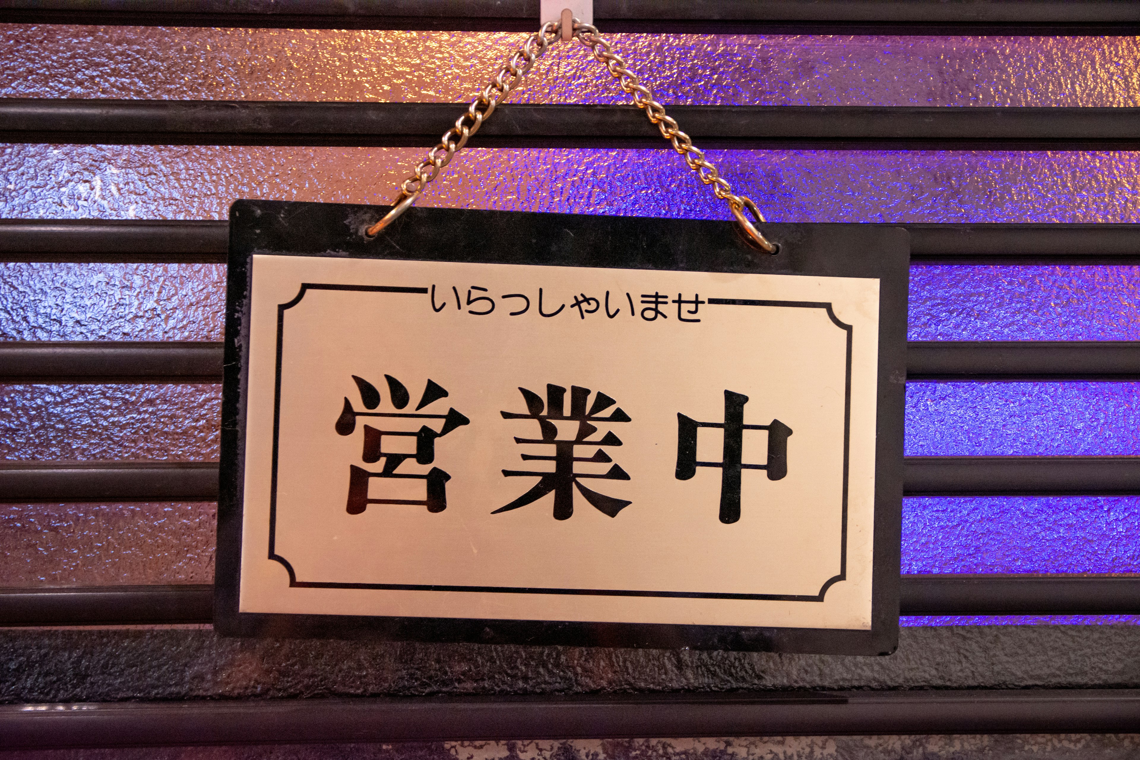 営業中の看板が黒い背景に飾られている