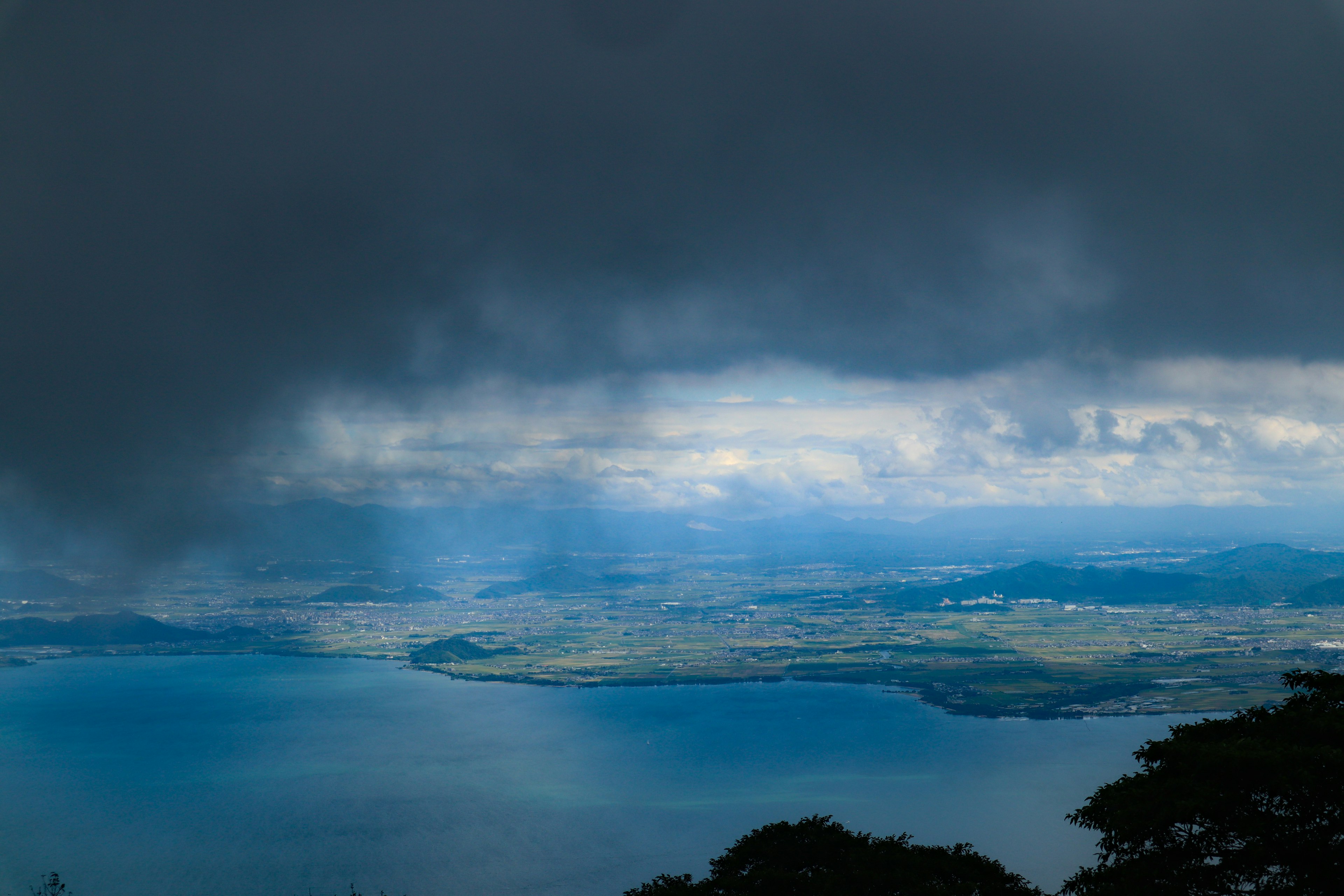 雲層下的湖泊和綠色丘陵的風景