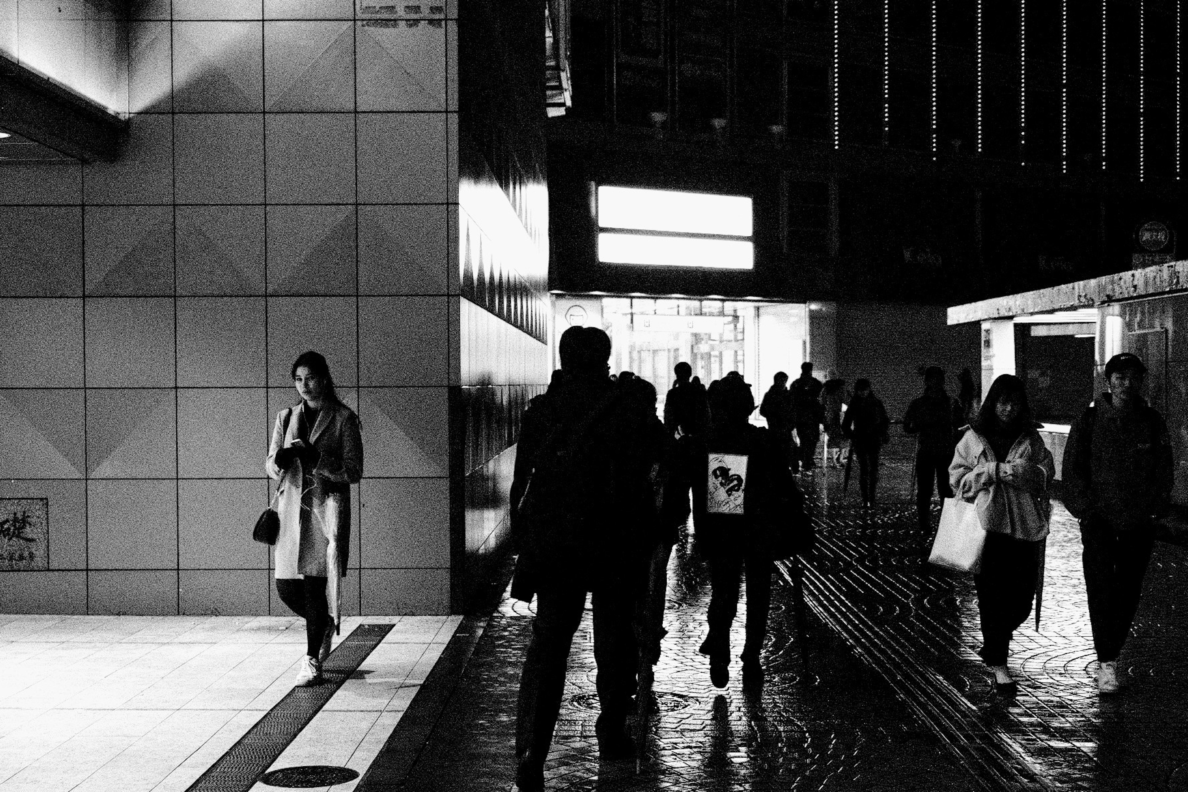 夜の街を歩く人々と反射した光のある風景