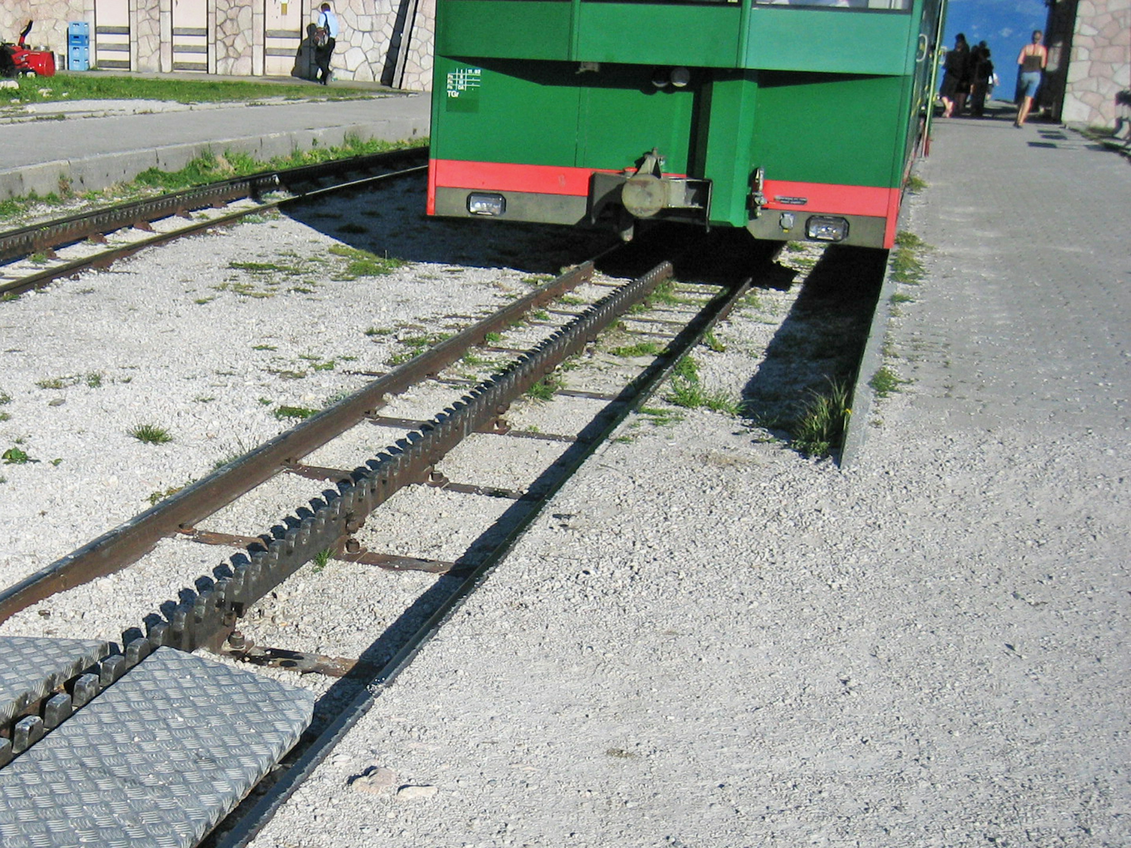 綠色電車停在鐵路上，周圍有碎石