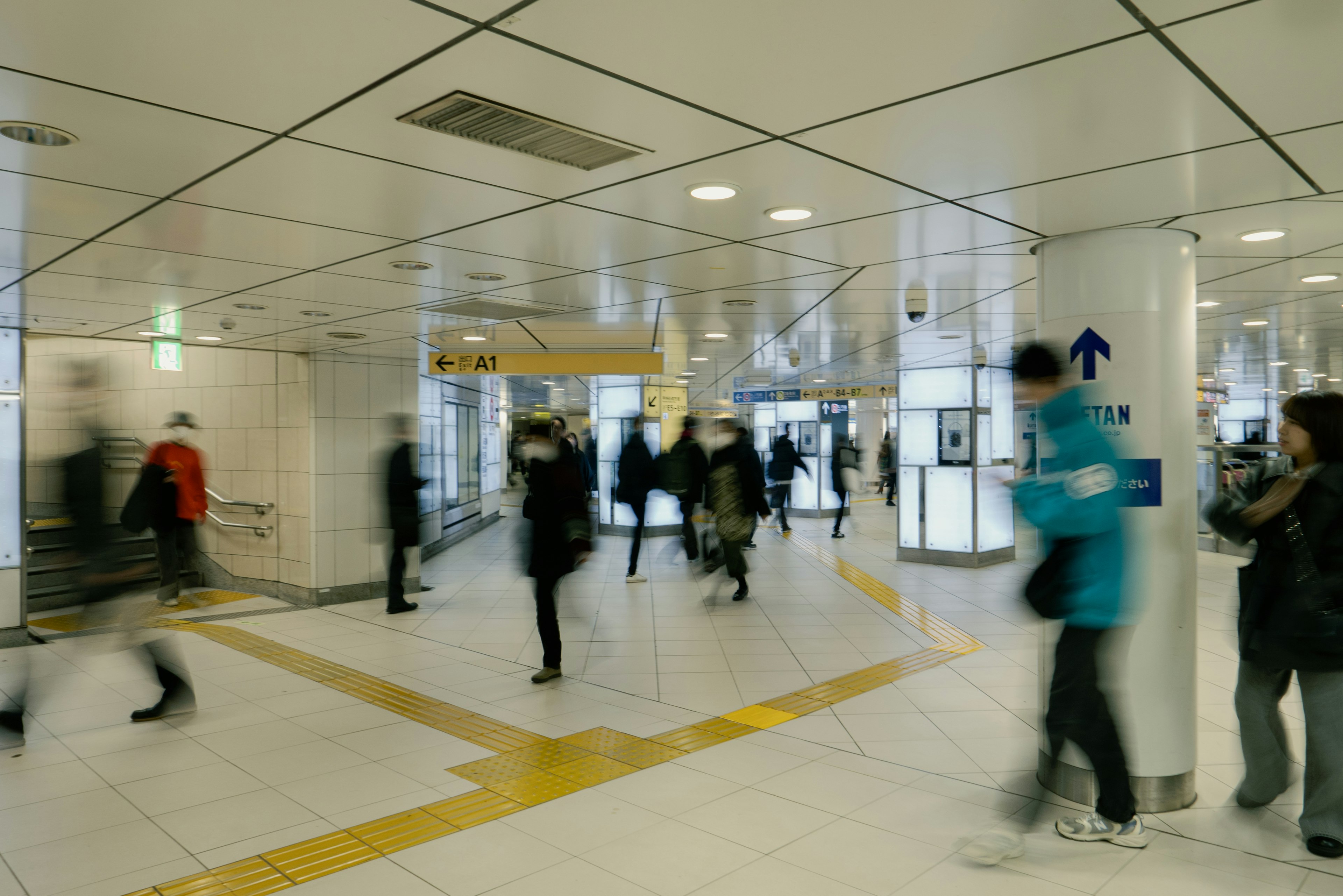 Corredor de estación de metro ocupado con personas caminando