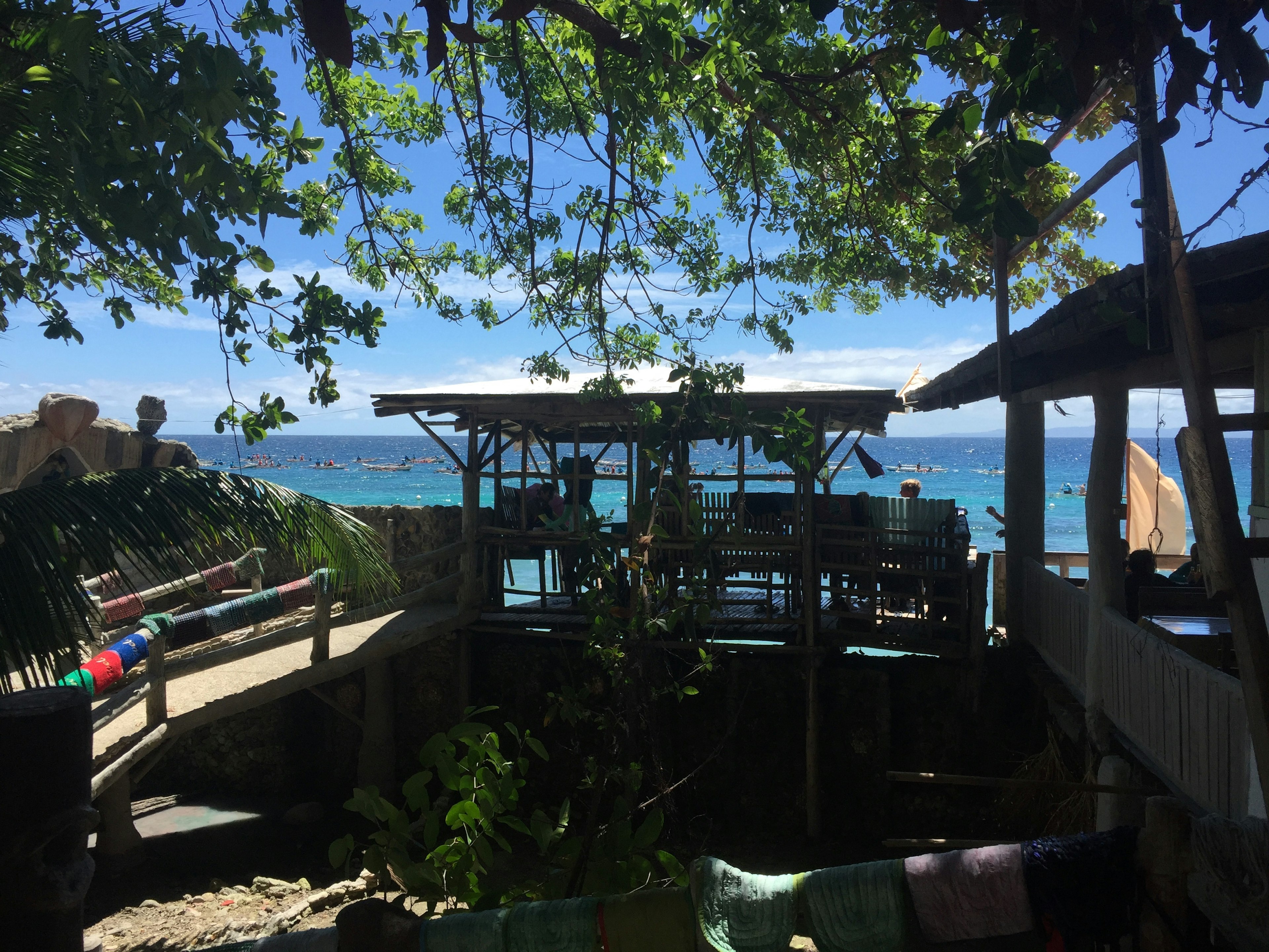 Vista panoramica di una capanna sulla spiaggia circondata da alberi verdi e oceano blu