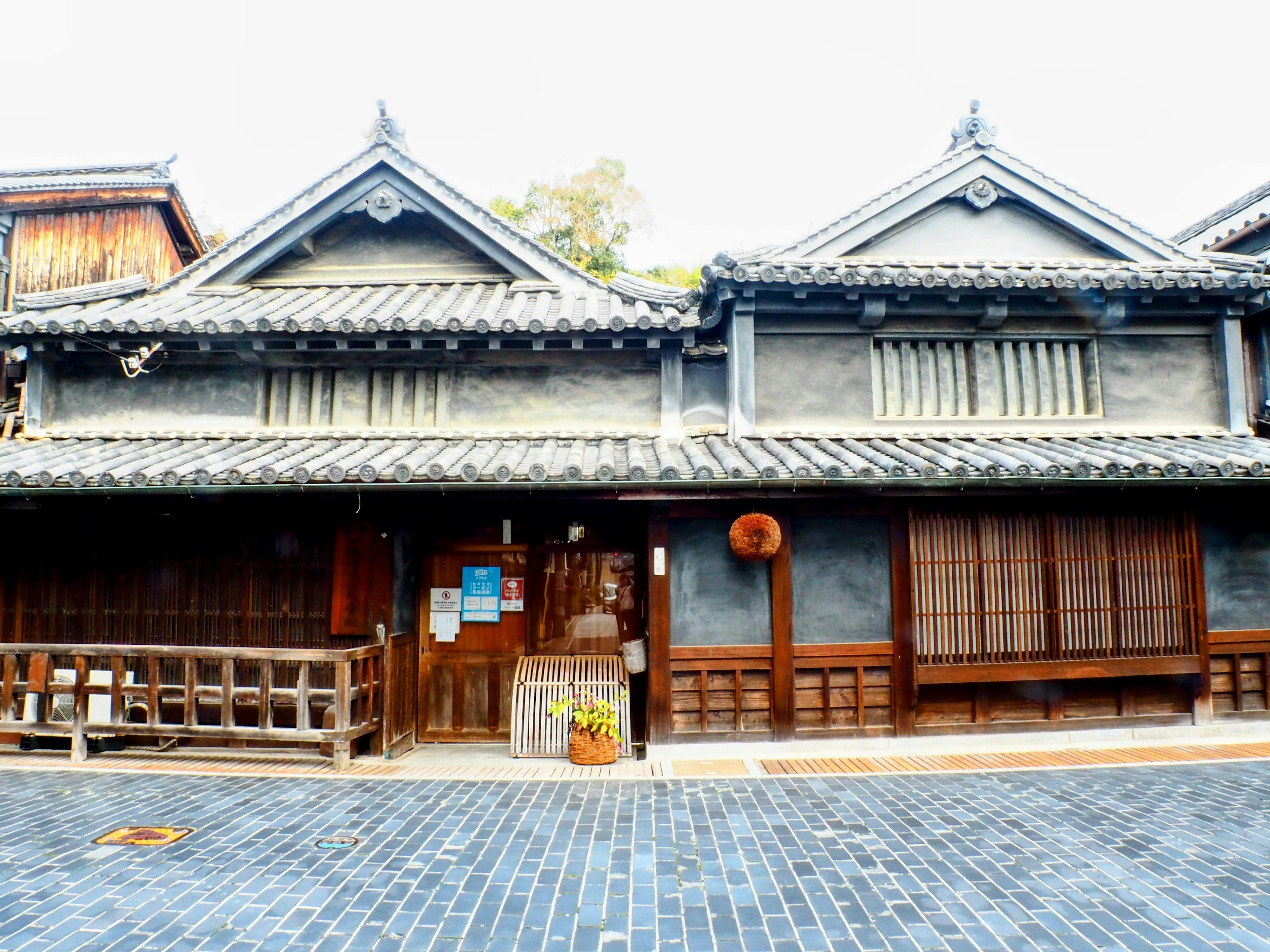 Fachada de una casa japonesa tradicional con techo claro y ventanas de madera