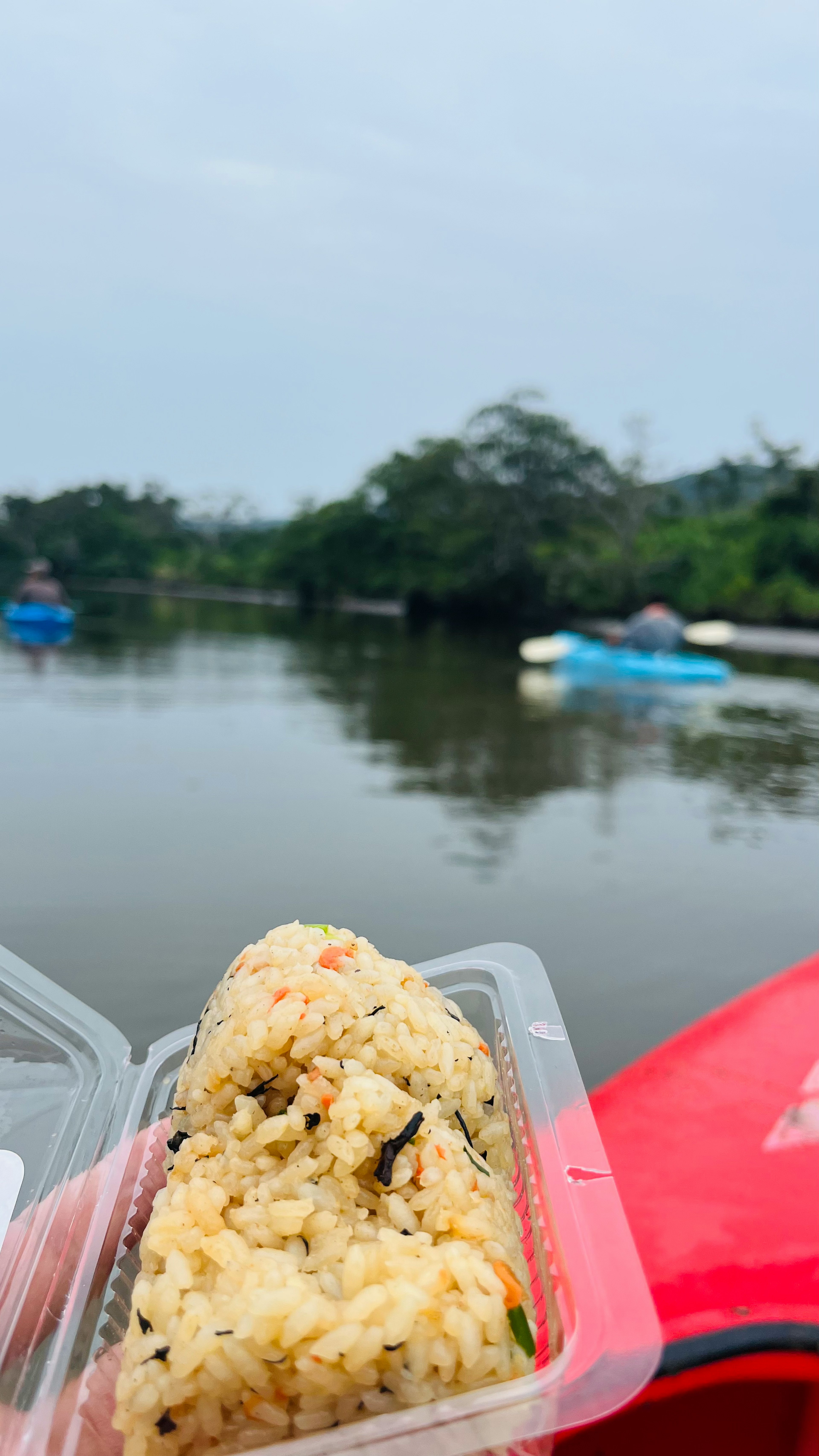 Onigiri gehalten in der Nähe eines Flusses mit ruhigem Wasser