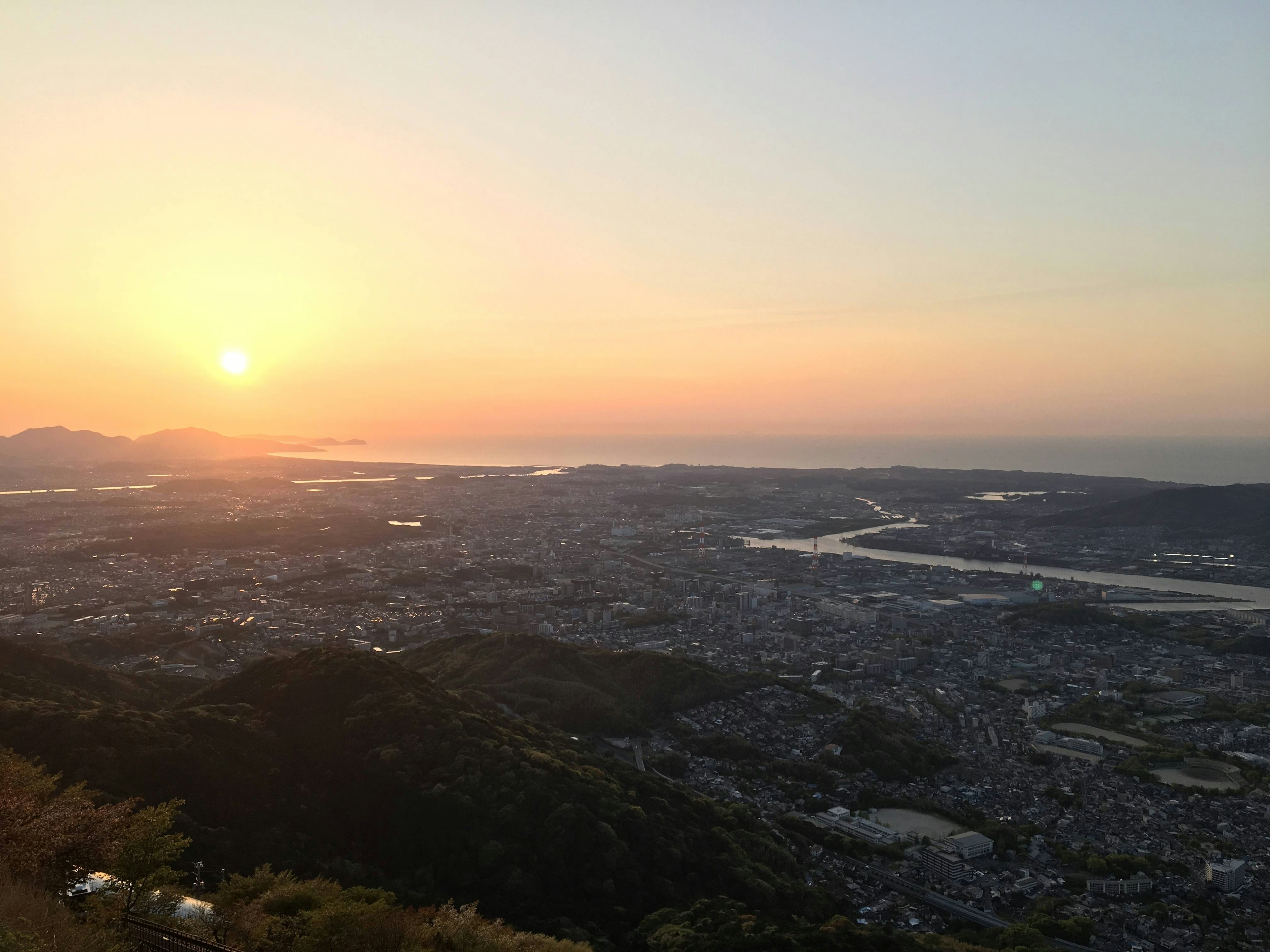 Panoramic view of a city at sunset with a river