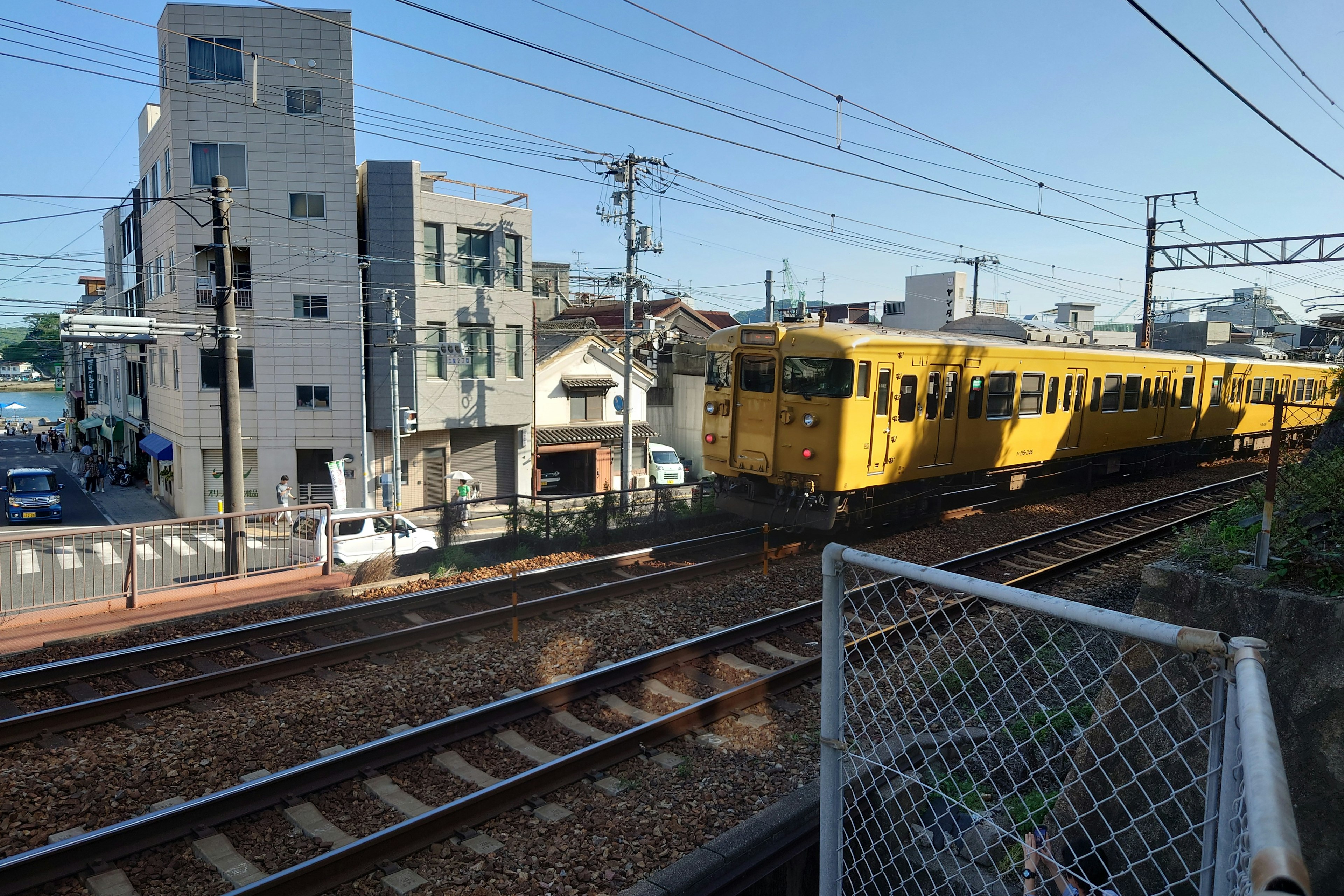 黄色い電車が線路を走る都市の風景