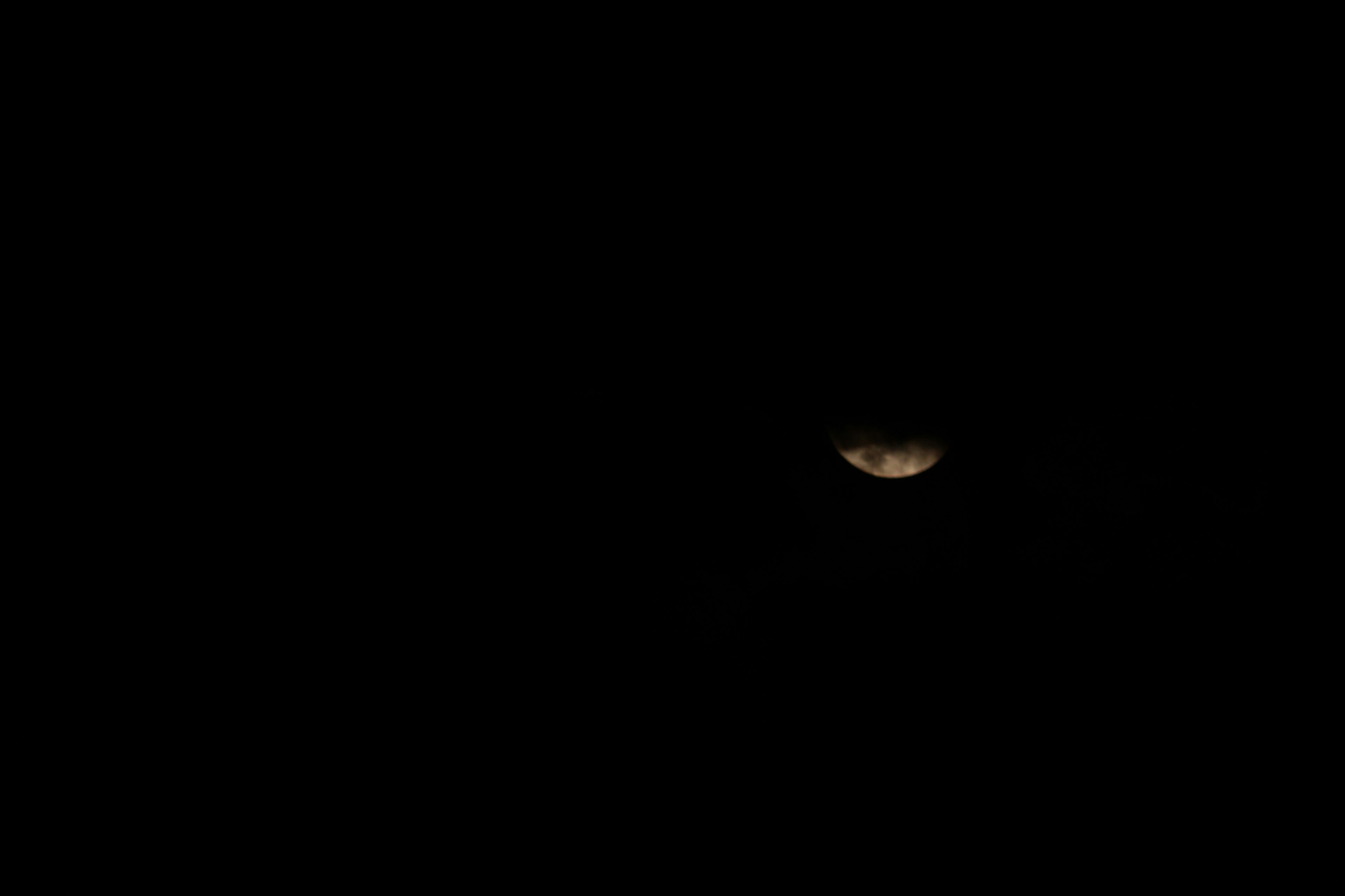 Partially illuminated moon against a dark background